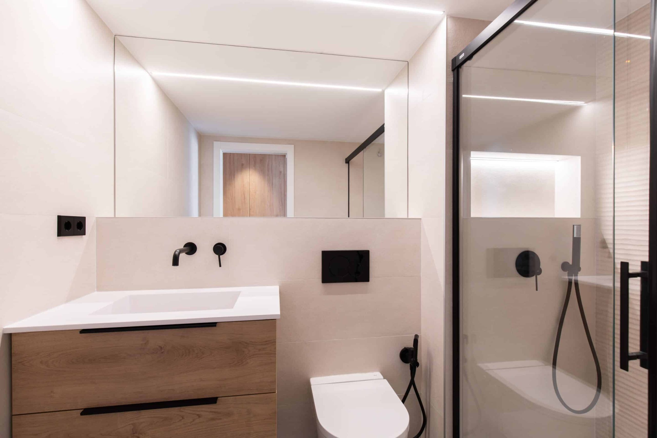 Baño con mueble de madera y ducha acristalada