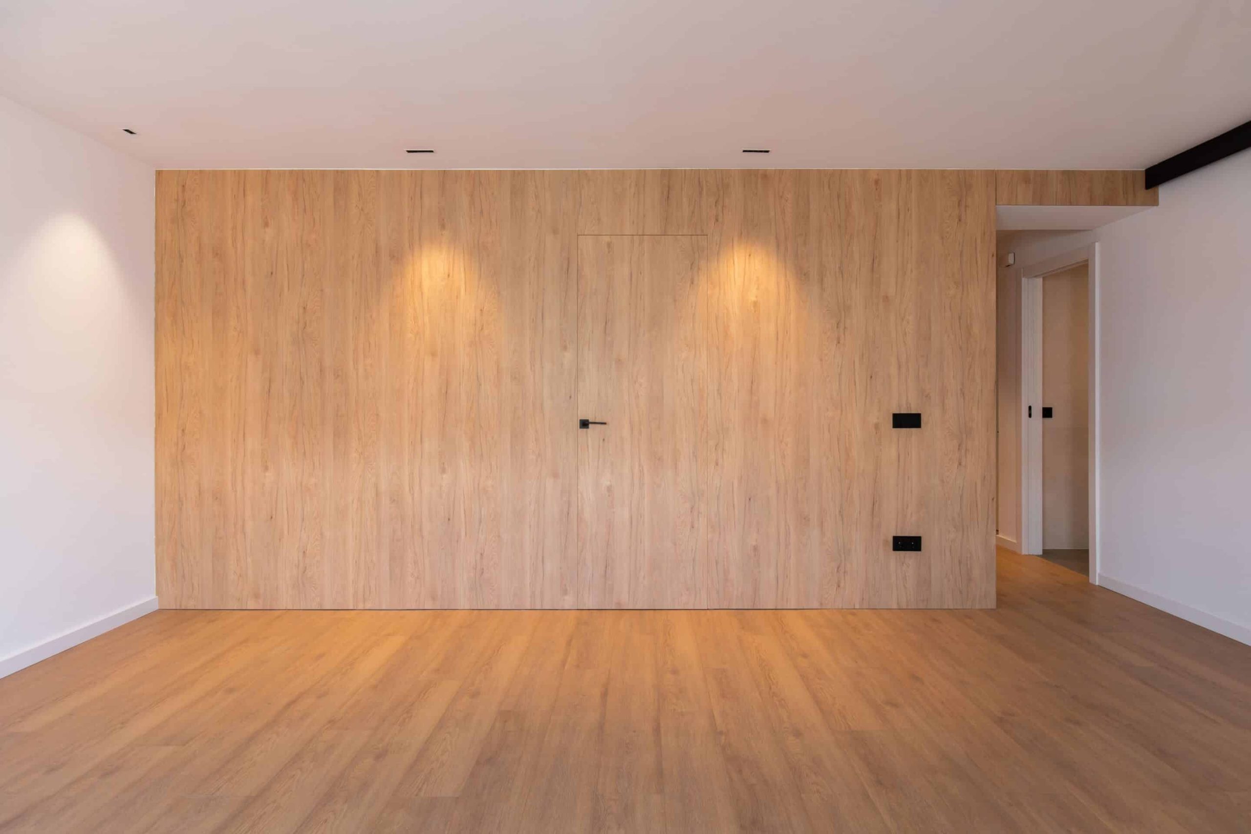 Pared revestida de madera con puerta oculta en el salón