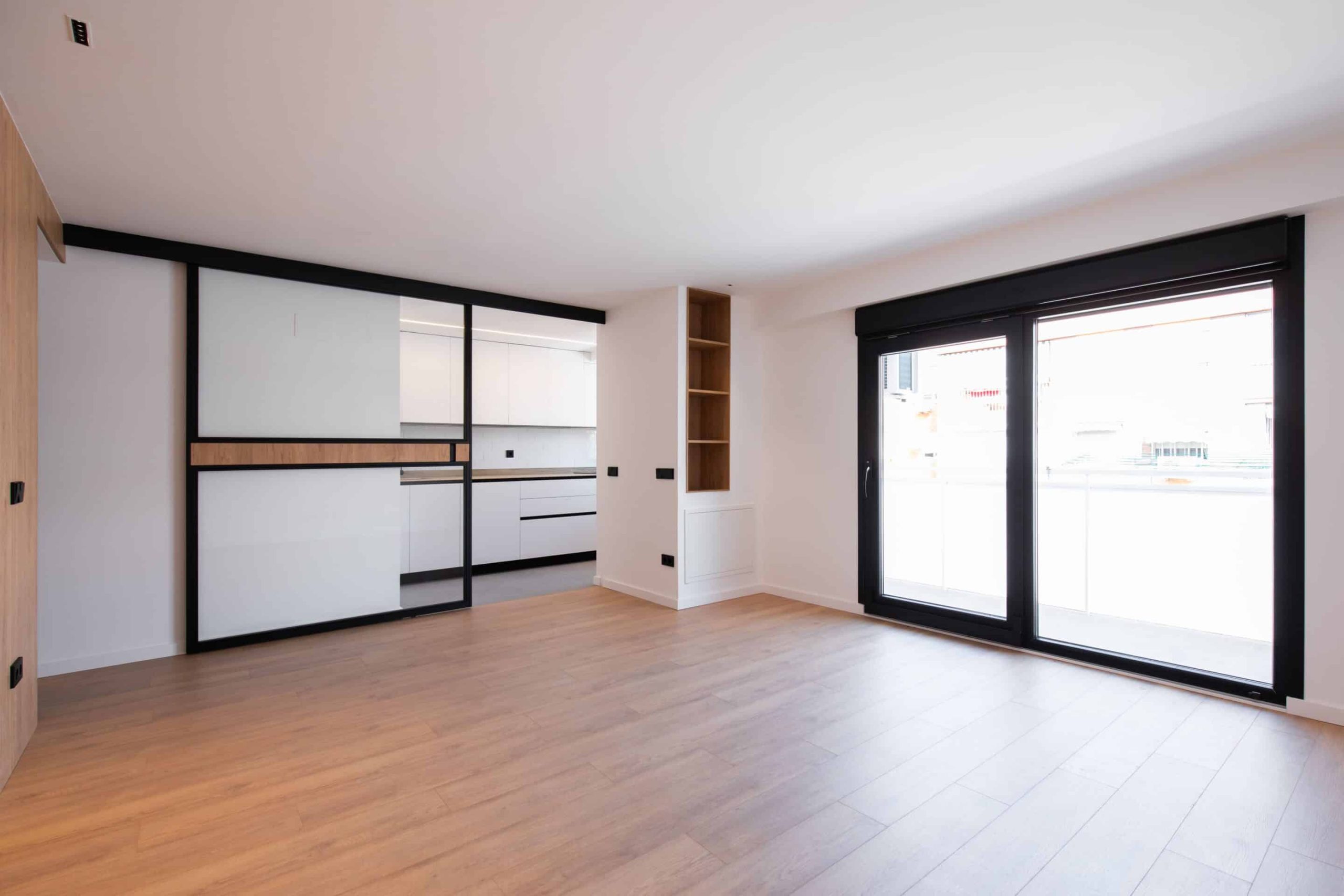 Salón con cocina acristalada y salida a la terraza