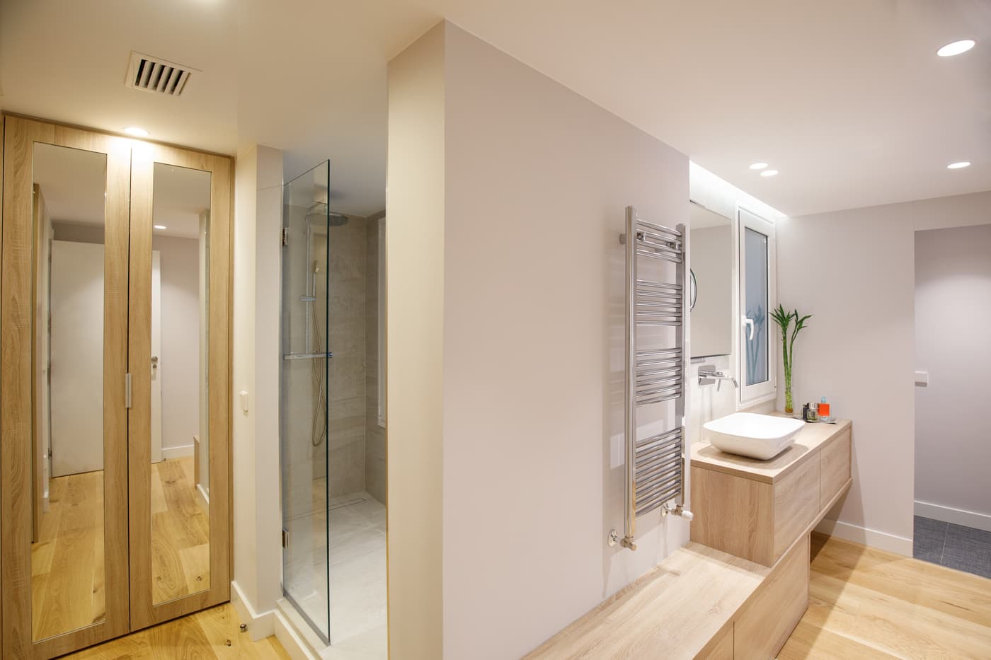 Baño con ducha y armario de madera