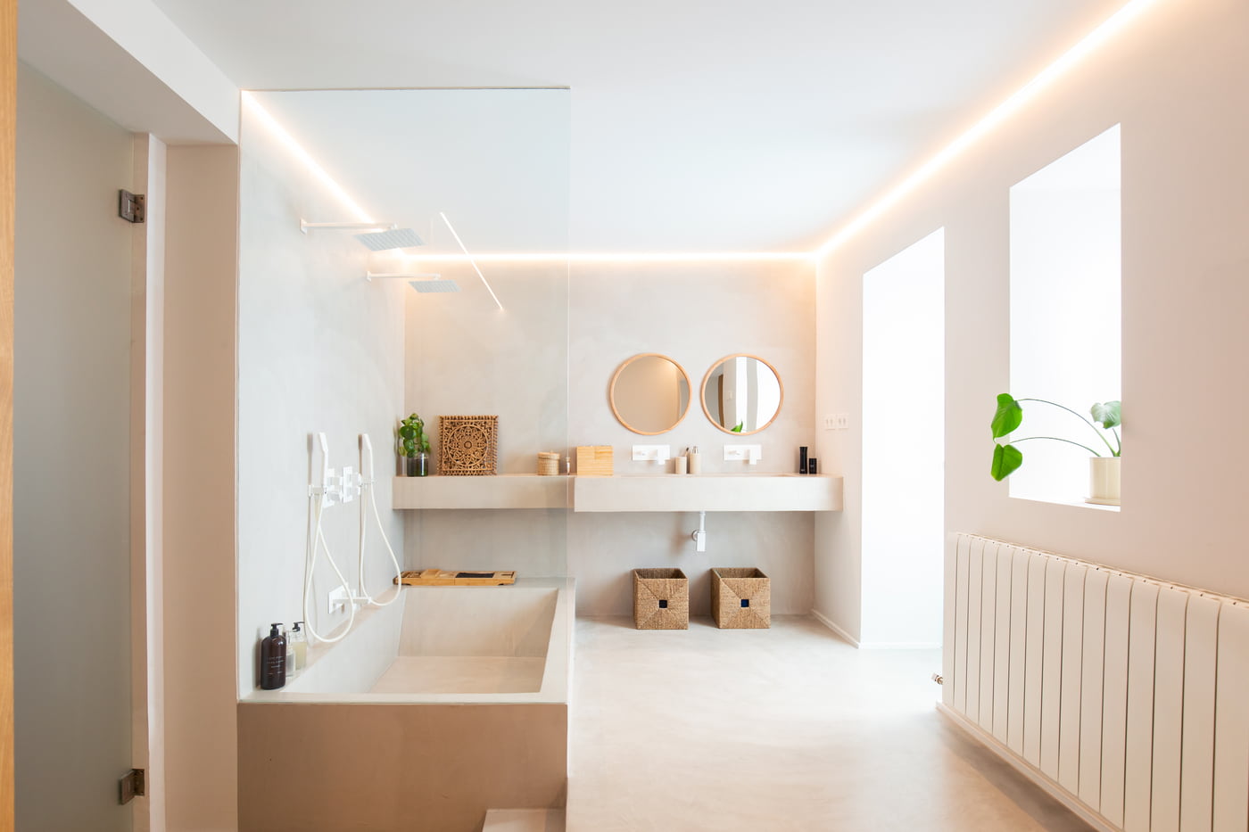 Baño reformado con bañera de obra y lavabo de microcemento