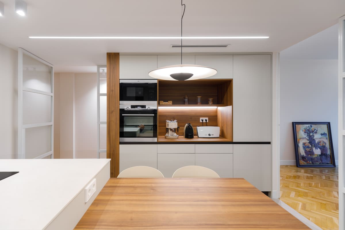 Cocina con columna de hornos y nicho de madera