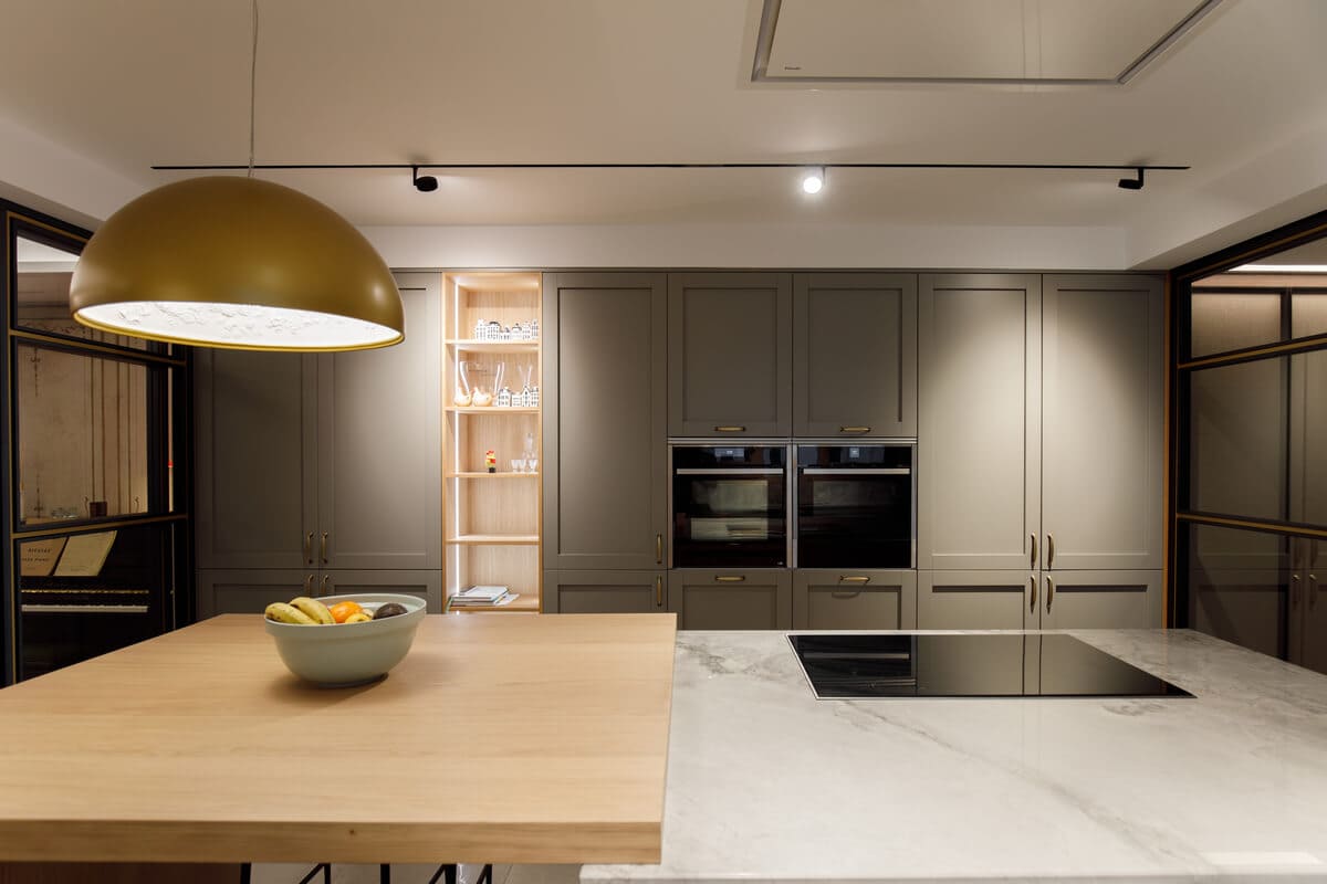 Cocina con columnas verde oscuro e isla de madera