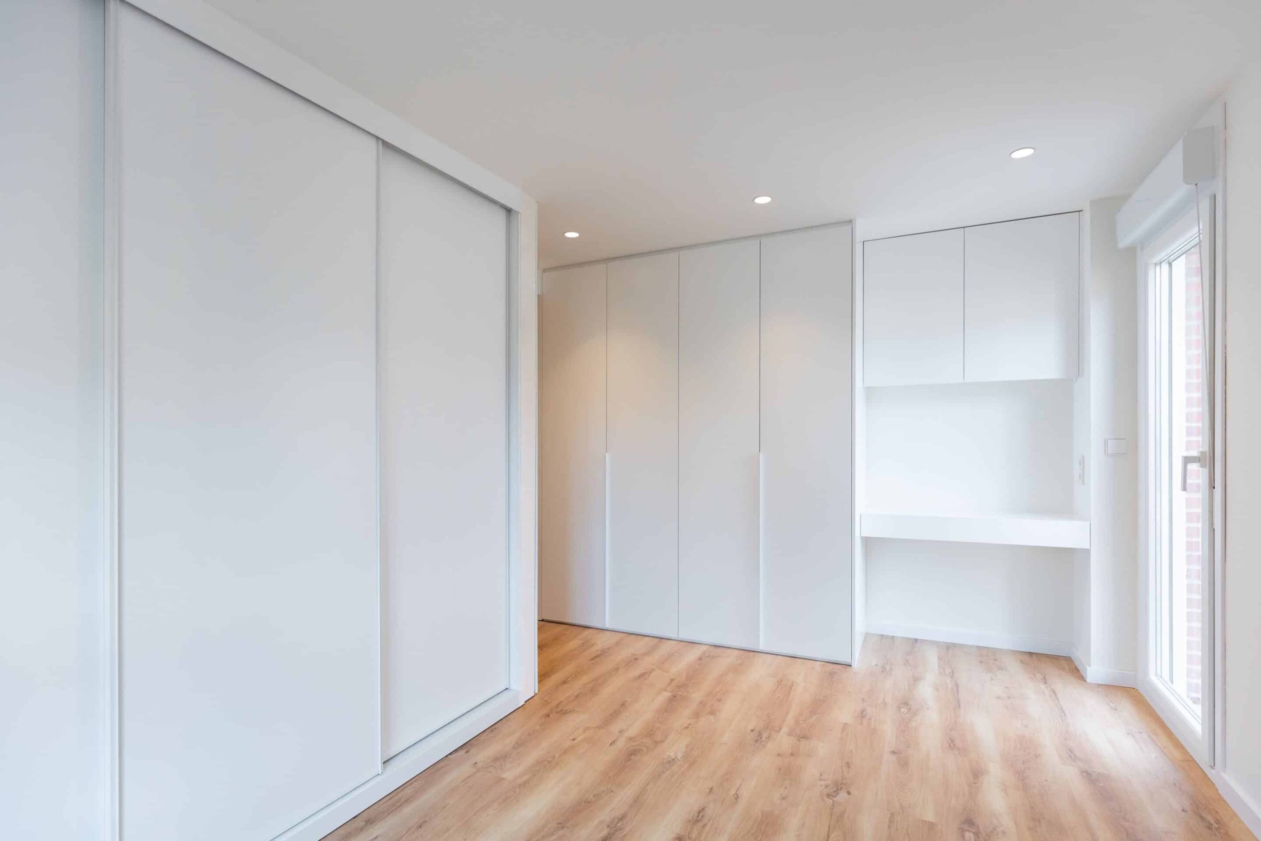 Dormitorio con armario blanco y escritorio integrado