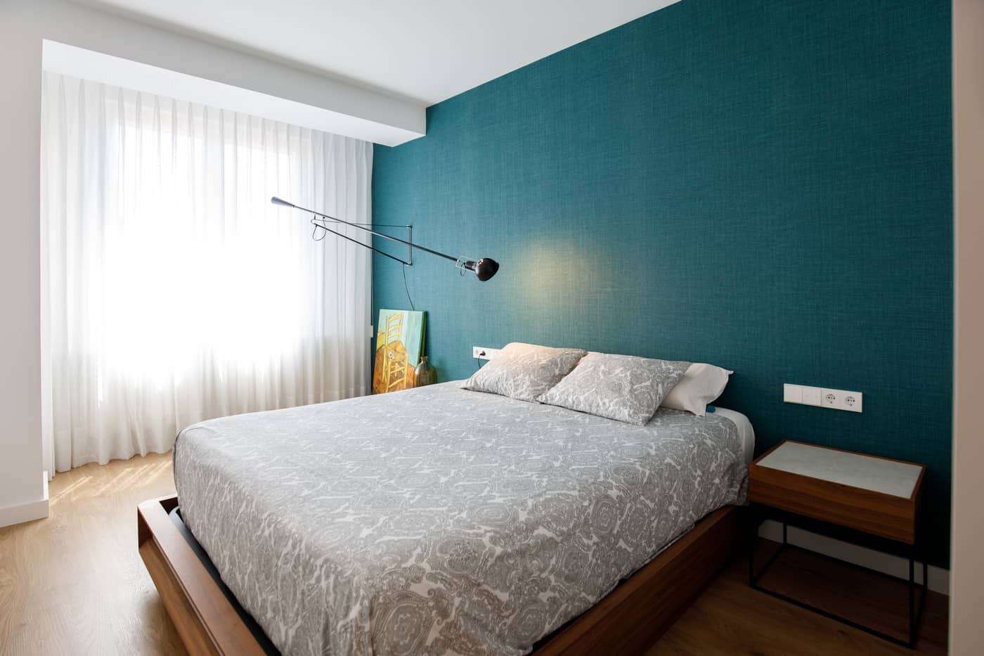 Dormitorio reformado con pared turquesa