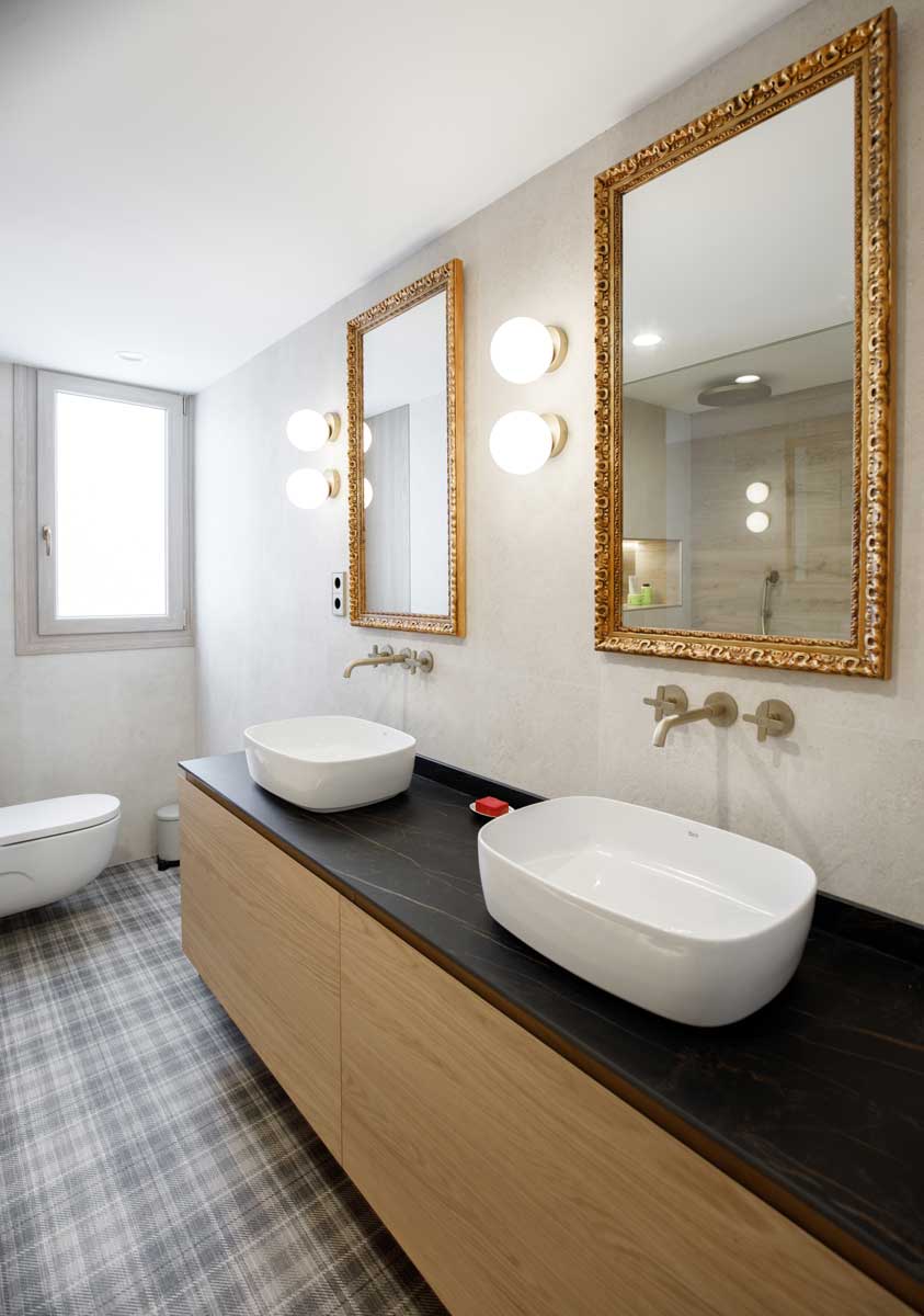 Lavabo doble con espejos dorados tras la reforma