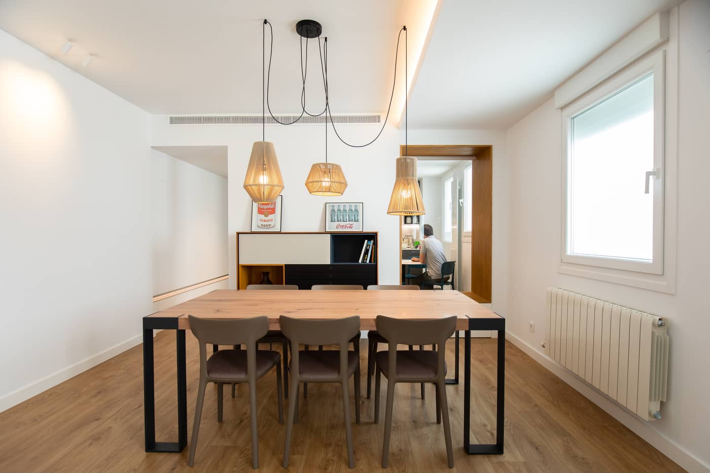 Mesa de comedor bajo lámparas de mimbre