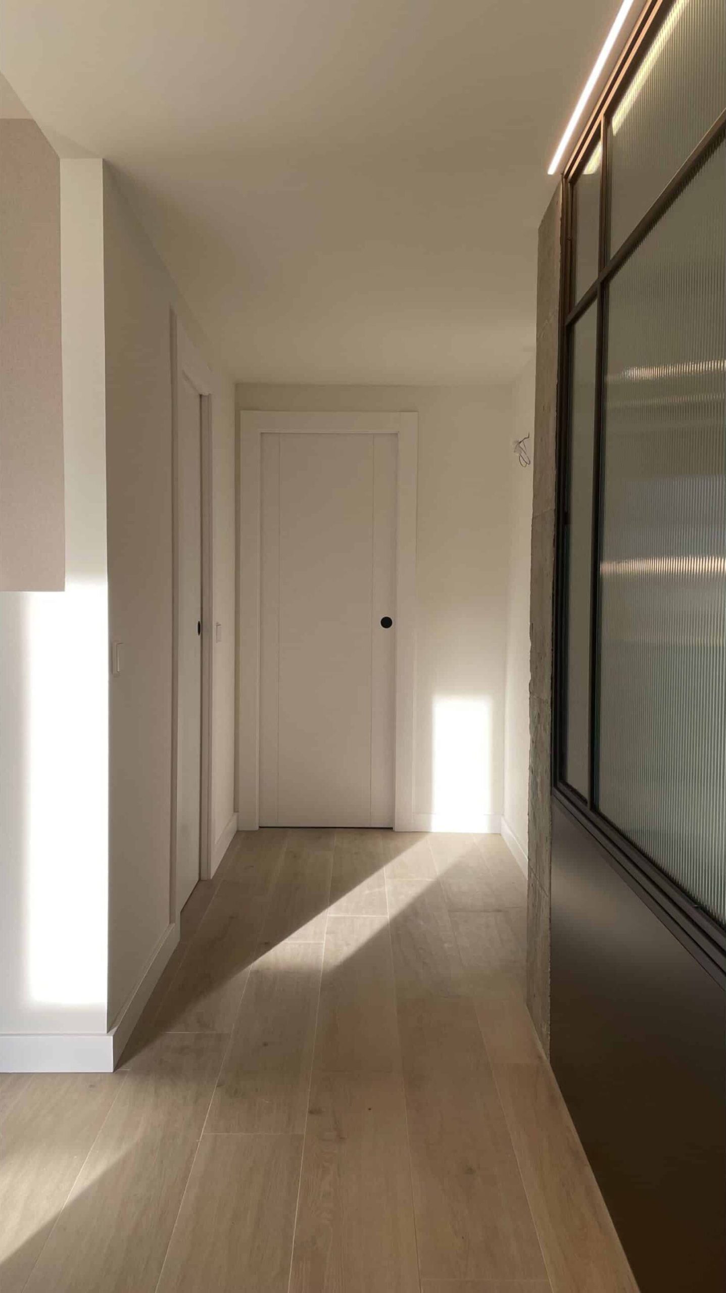 Pasillo luminoso con suelo de madera