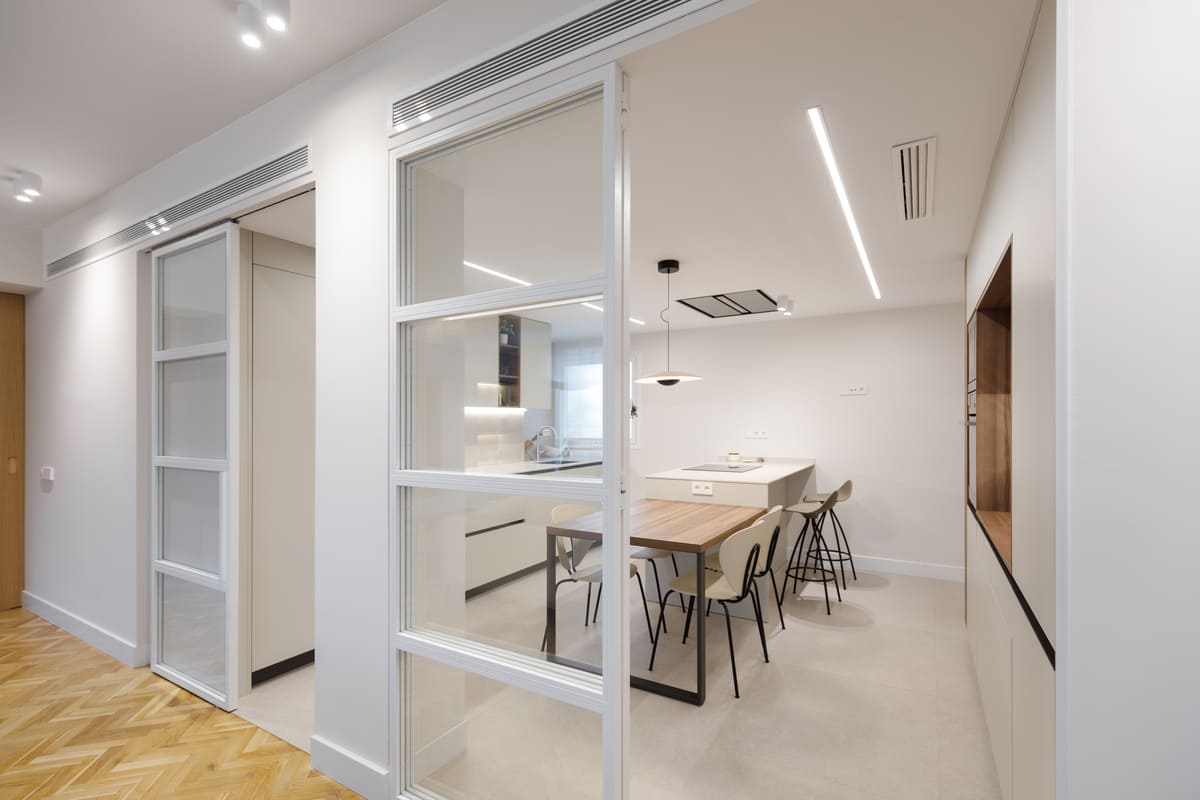 Puertas correderas blancas de cristal hacia la cocina