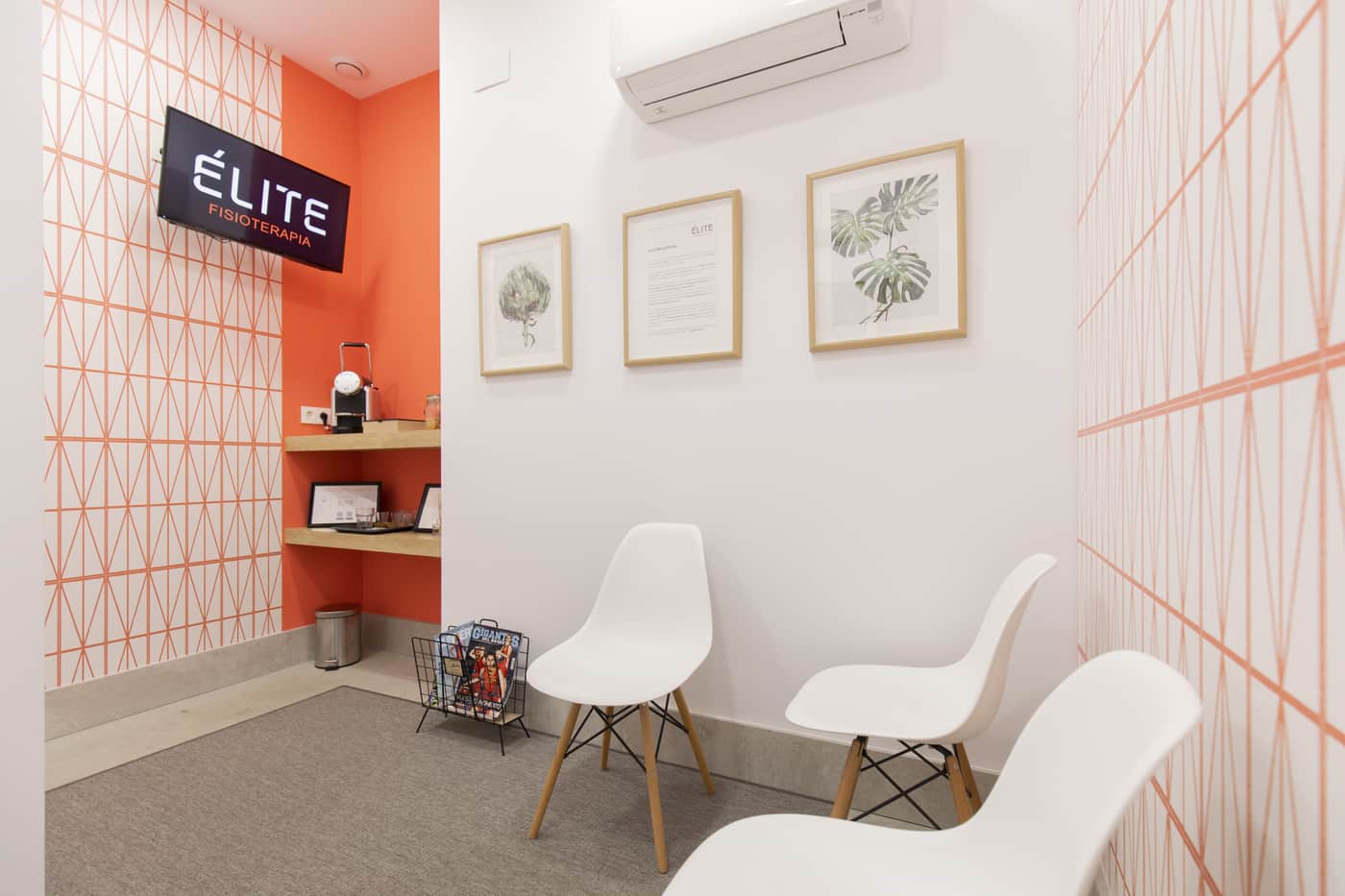 Sala de espera con pared naranja y sillas blancas
