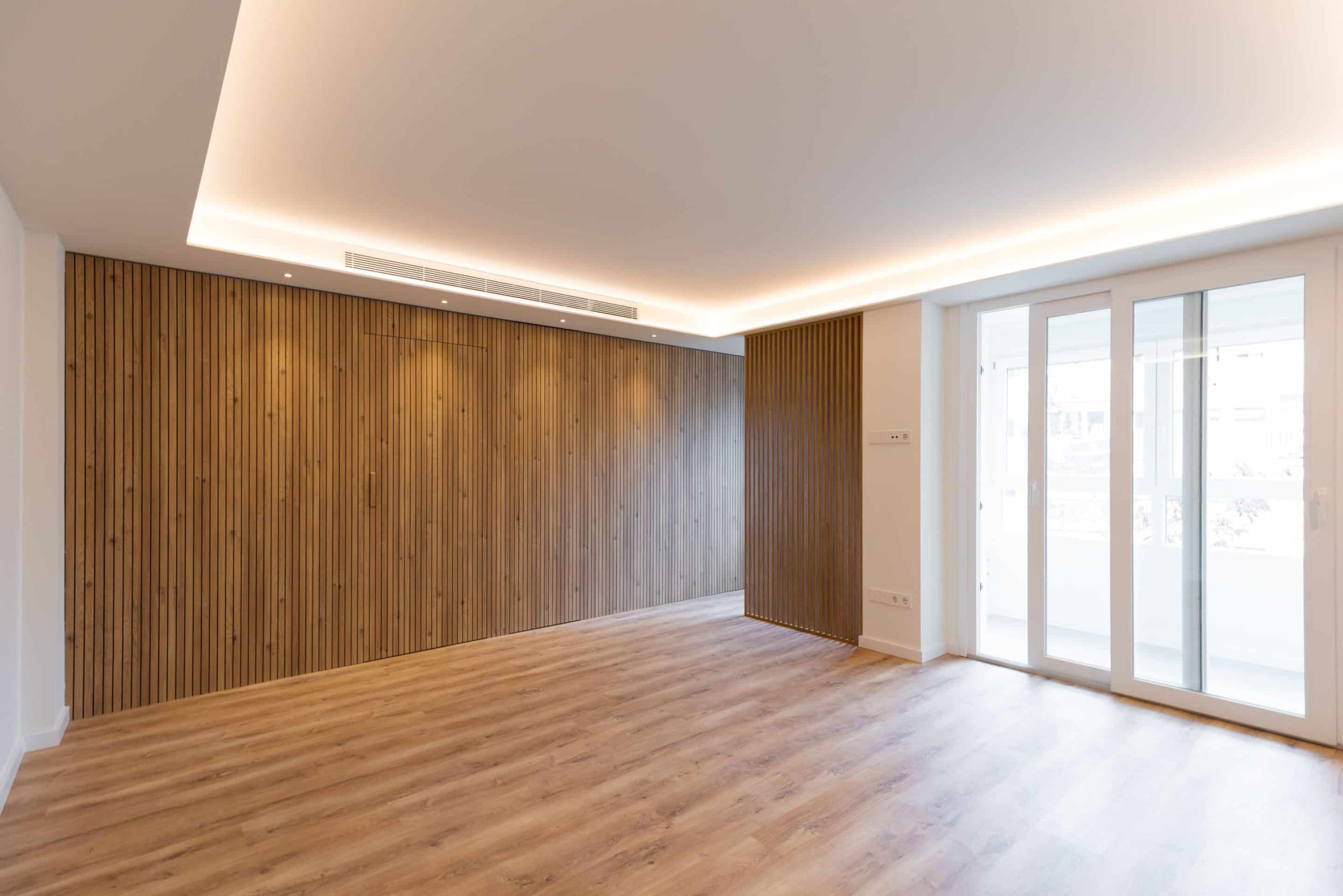 Salón con pared de listones y foseado de luz