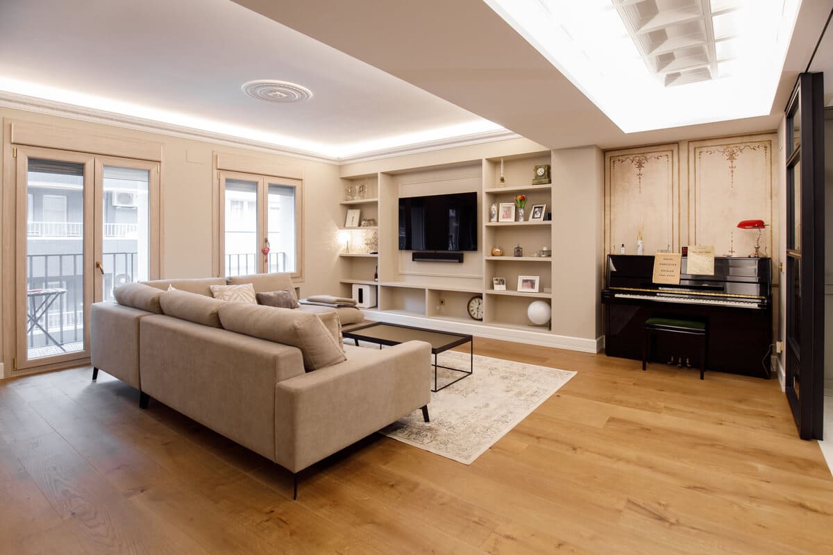 Salón con sofá chaise longue y librería a medida