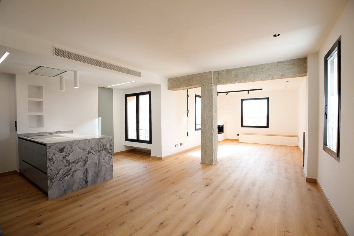 Salón diáfano con pilar de hormigón visto