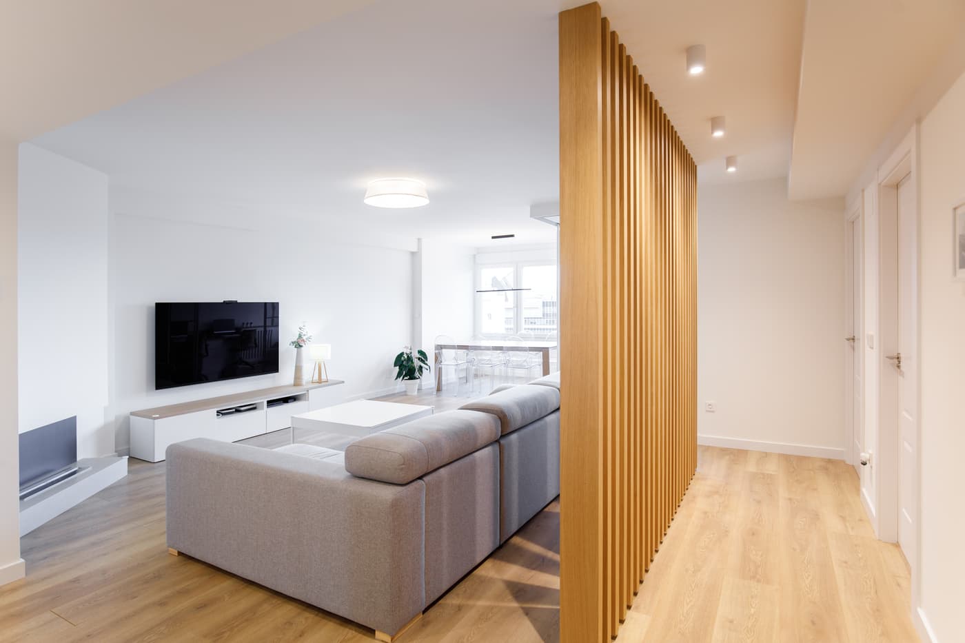 Salón reformado con lamas de madera y mueble blanco