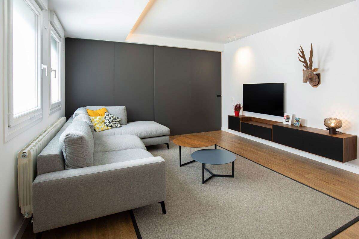 Salón reformado con sofá gris y mueble de televisión volado