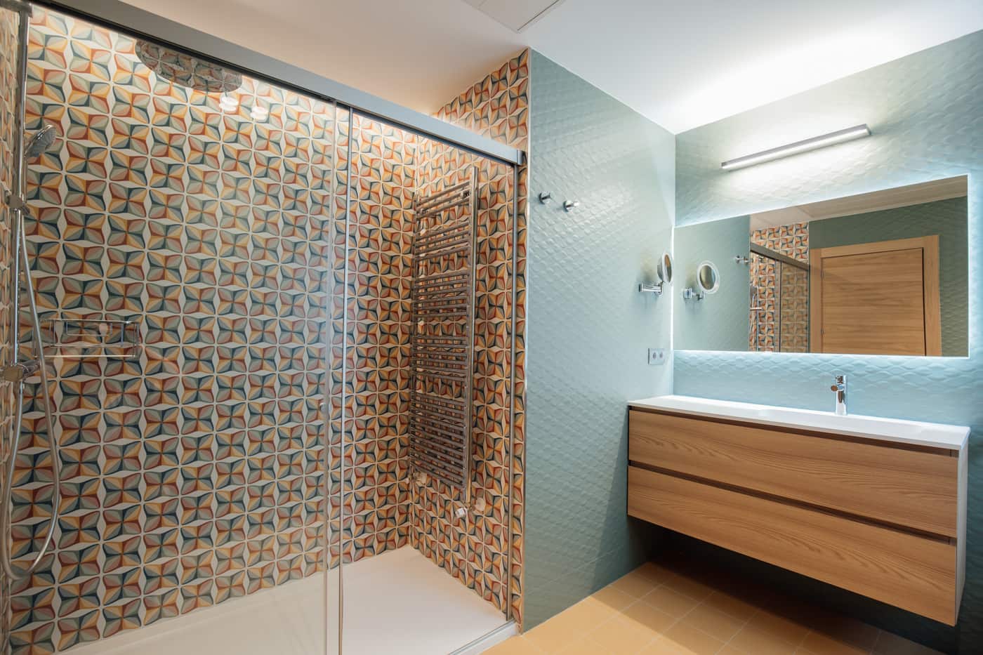 Baño con azulejo estampado en la ducha y mueble de madera