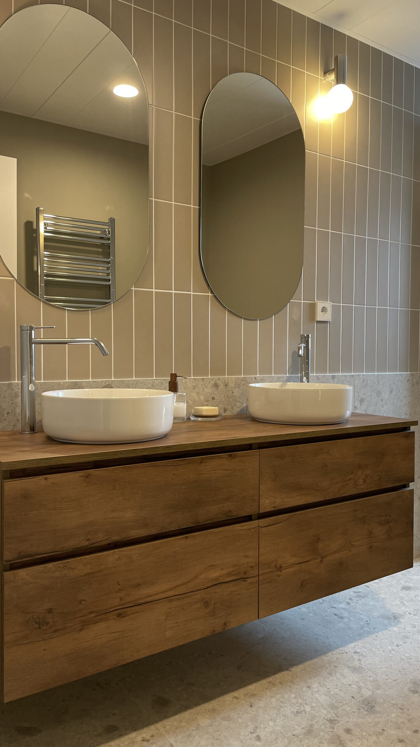 Lavabo doble con espejos ovalados y mueble de madera