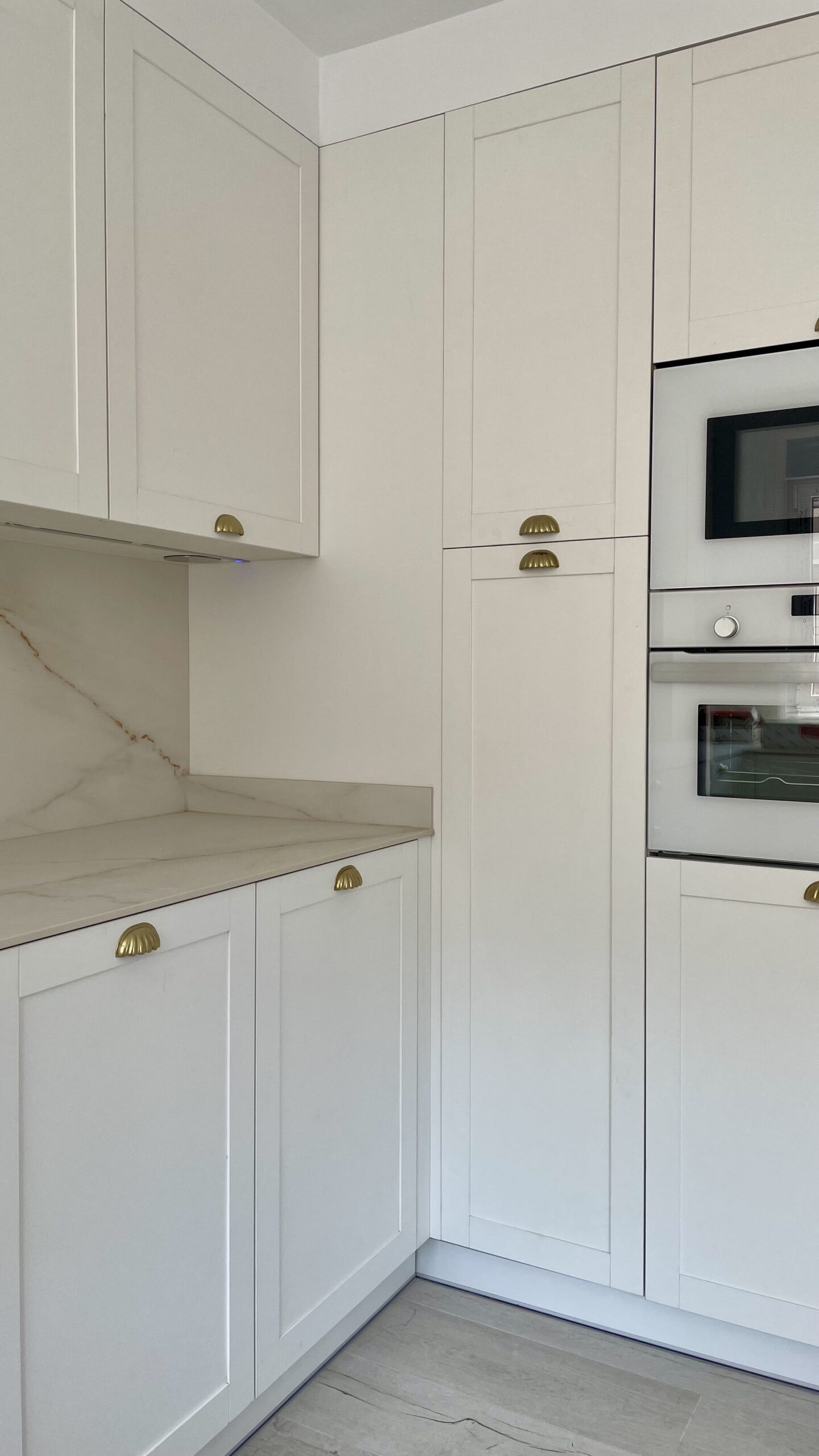 Cocina blanca de estilo clásico con tiradores dorados