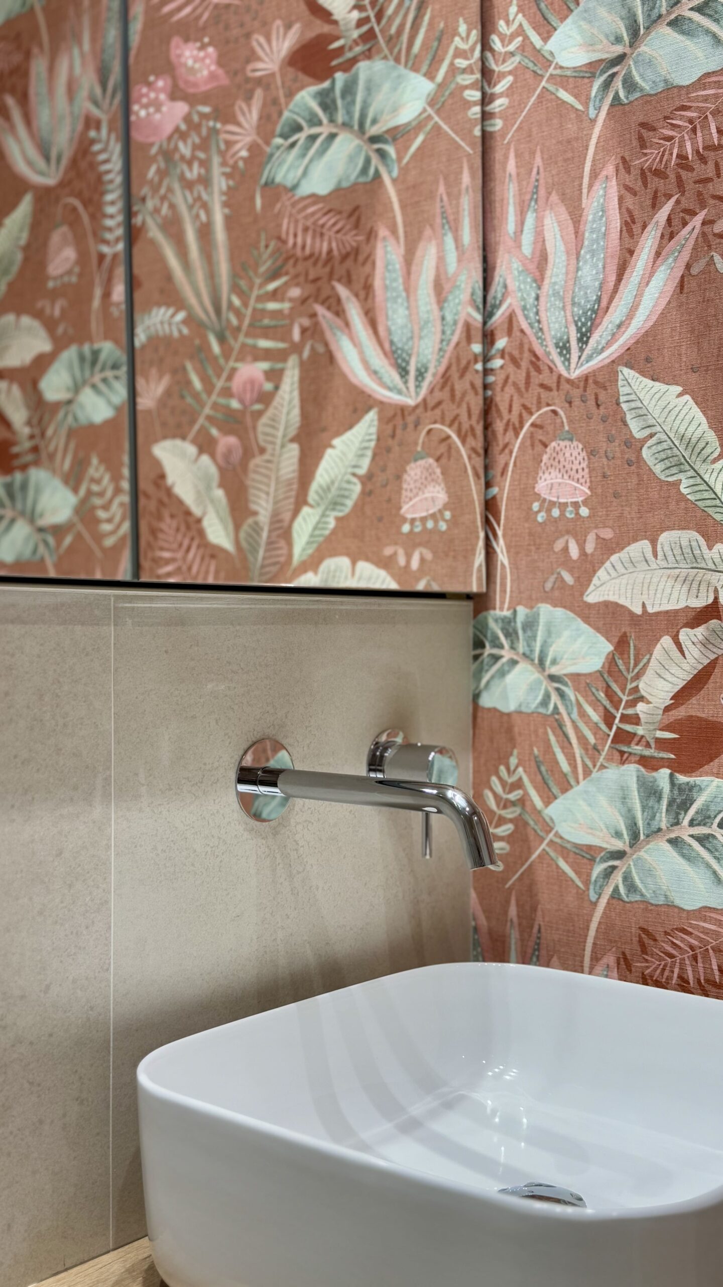 Lavabo con papel pintado floral en el baño reformado