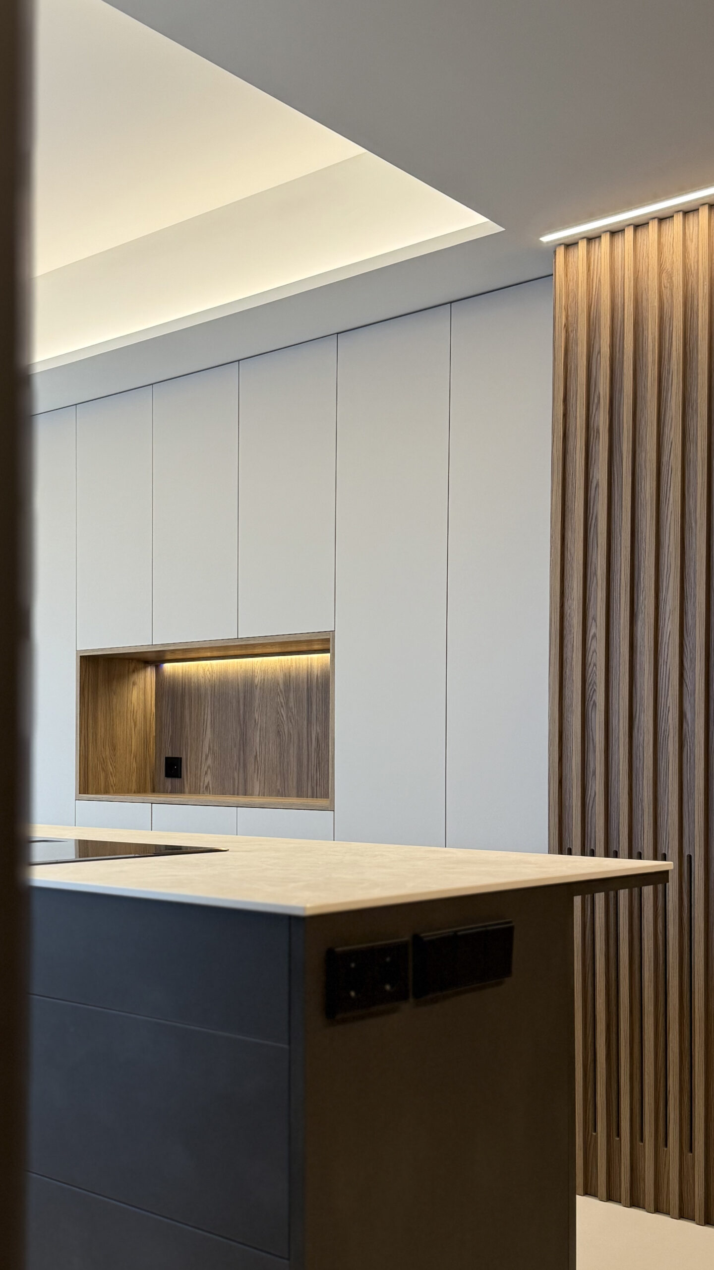 Cocina con columnas blancas y hornacina iluminada