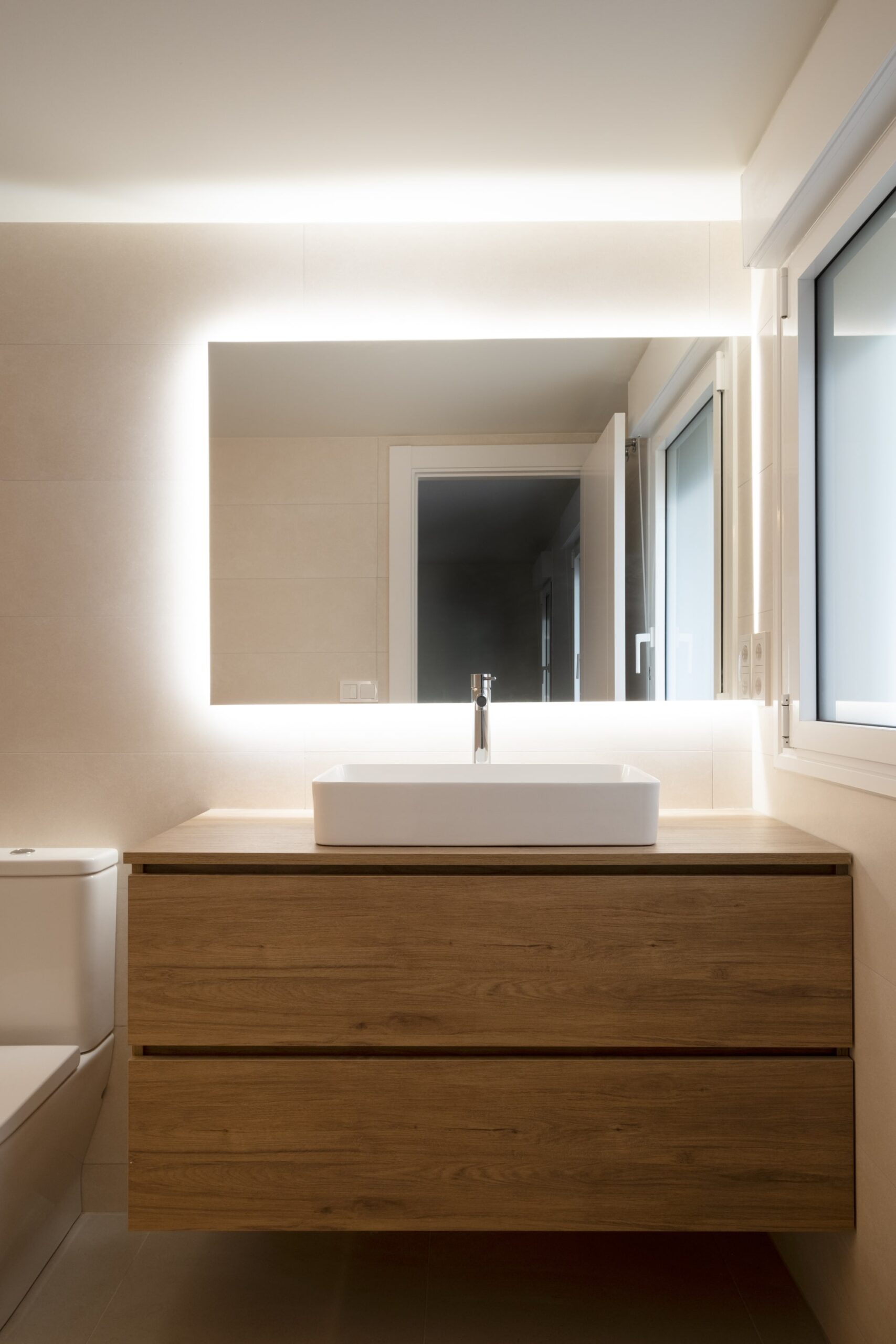 Baño reformado con espejo retroiluminado