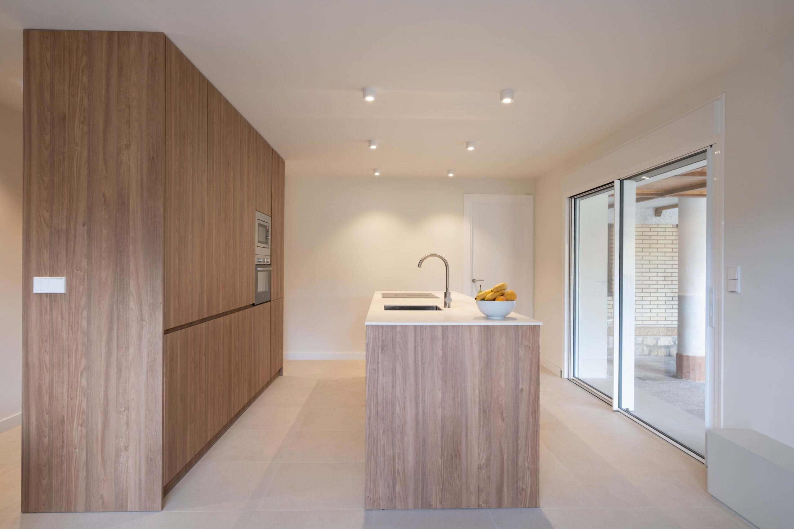 Cocina con isla de madera y salida al jardín