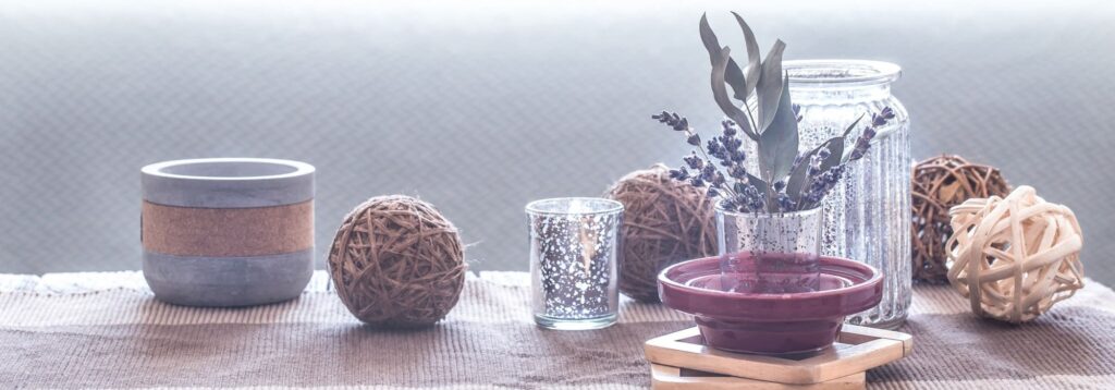 mesa con elementos decorativos naturaless velas y cestas en salon acogedor con sofa y cojines