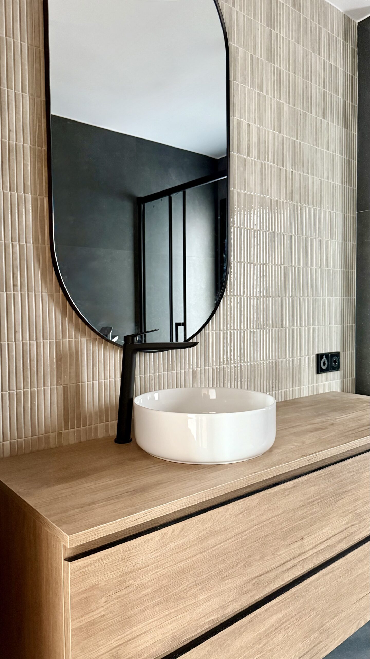 Baño con espejo ovalado y lavabo redondo