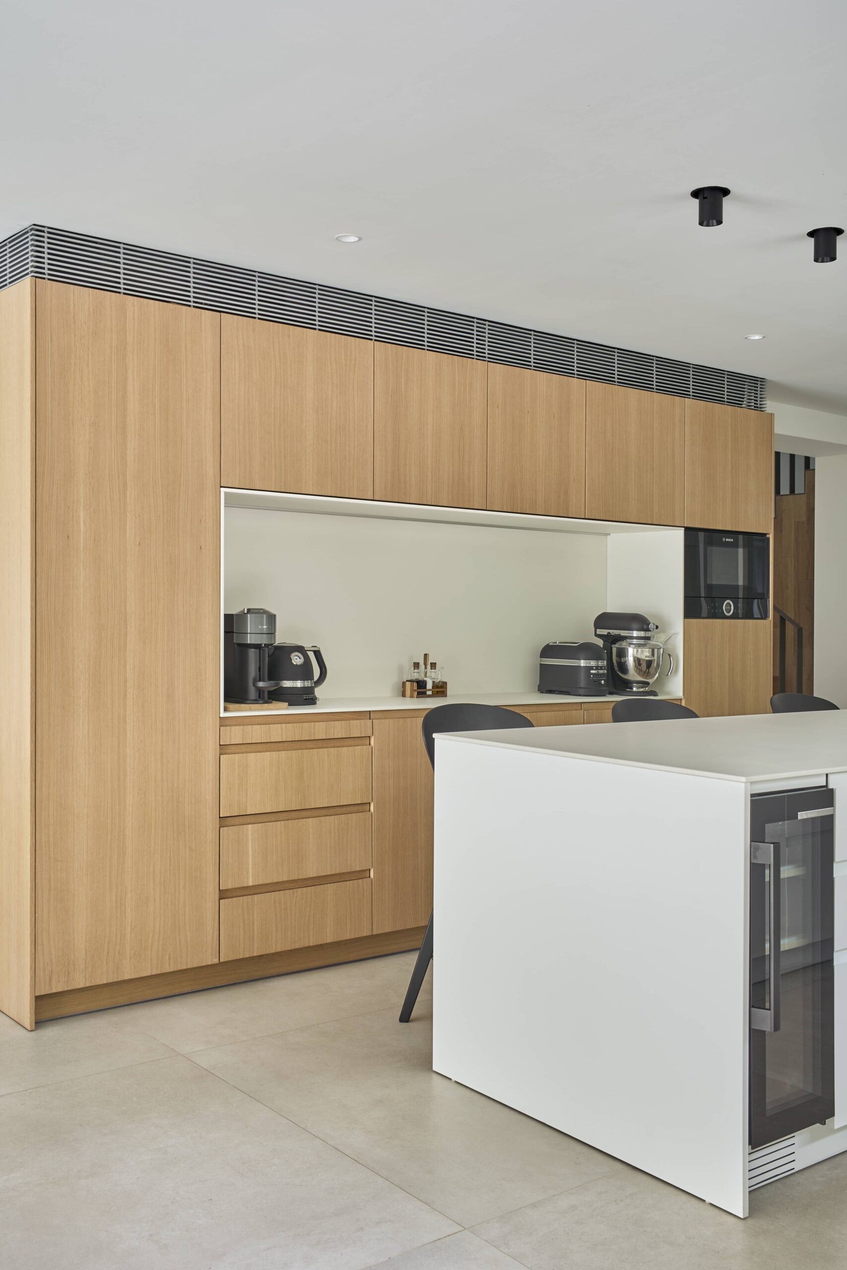 Cocina con columnas de madera e isla blanca
