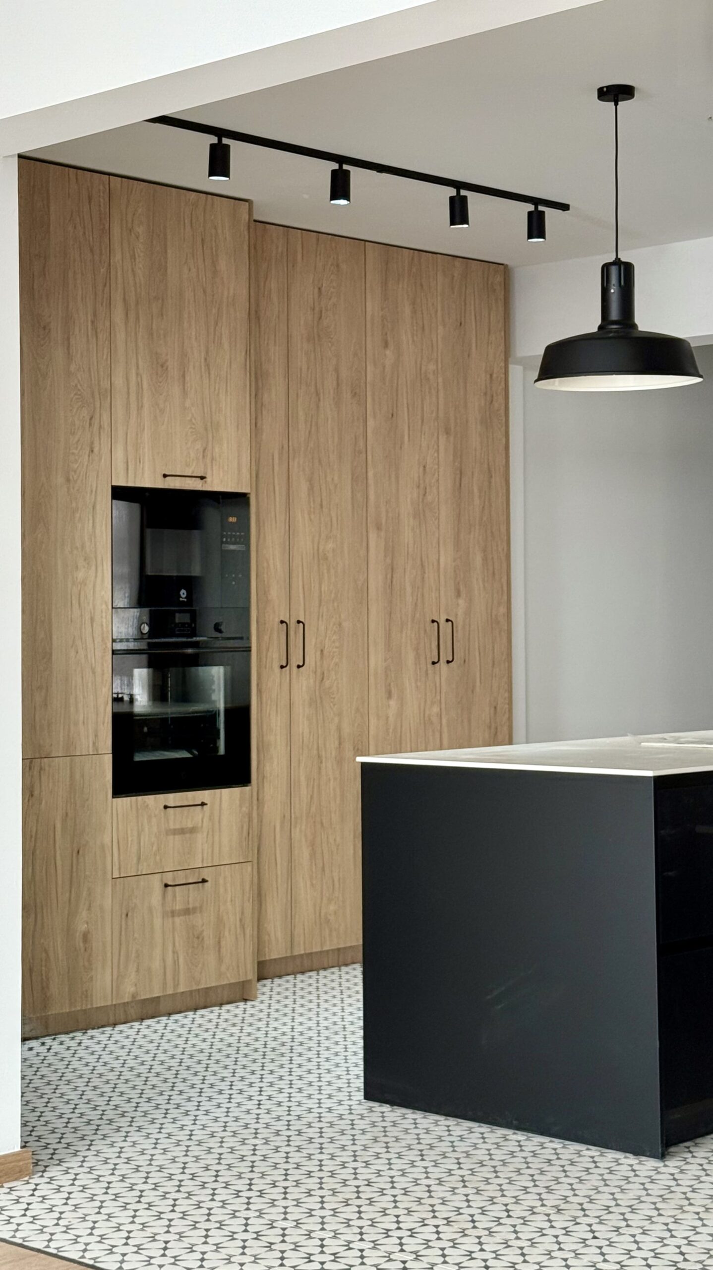 Columnas de madera con hornos e isla negra