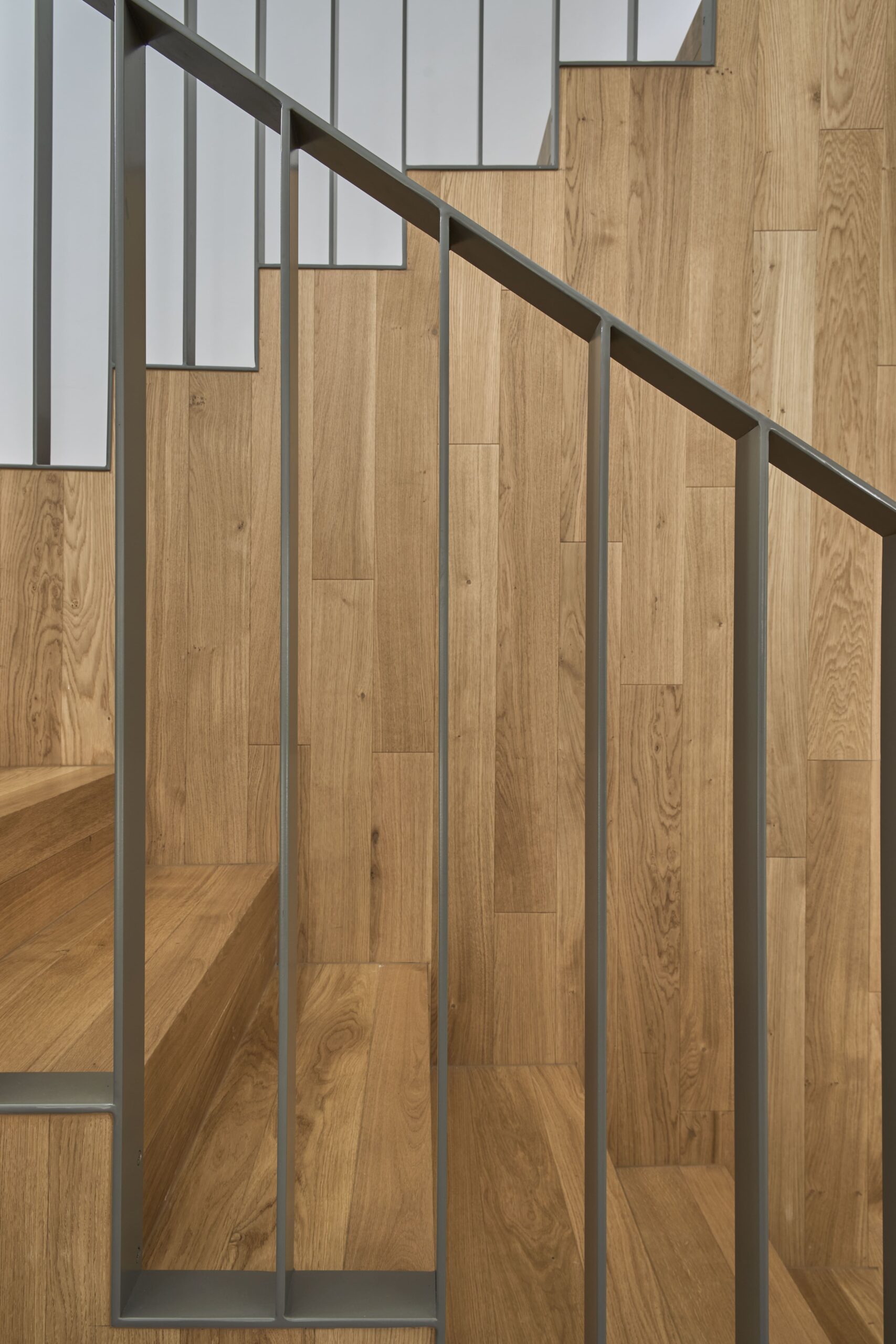 Escalera de roble con barandilla metálica gris