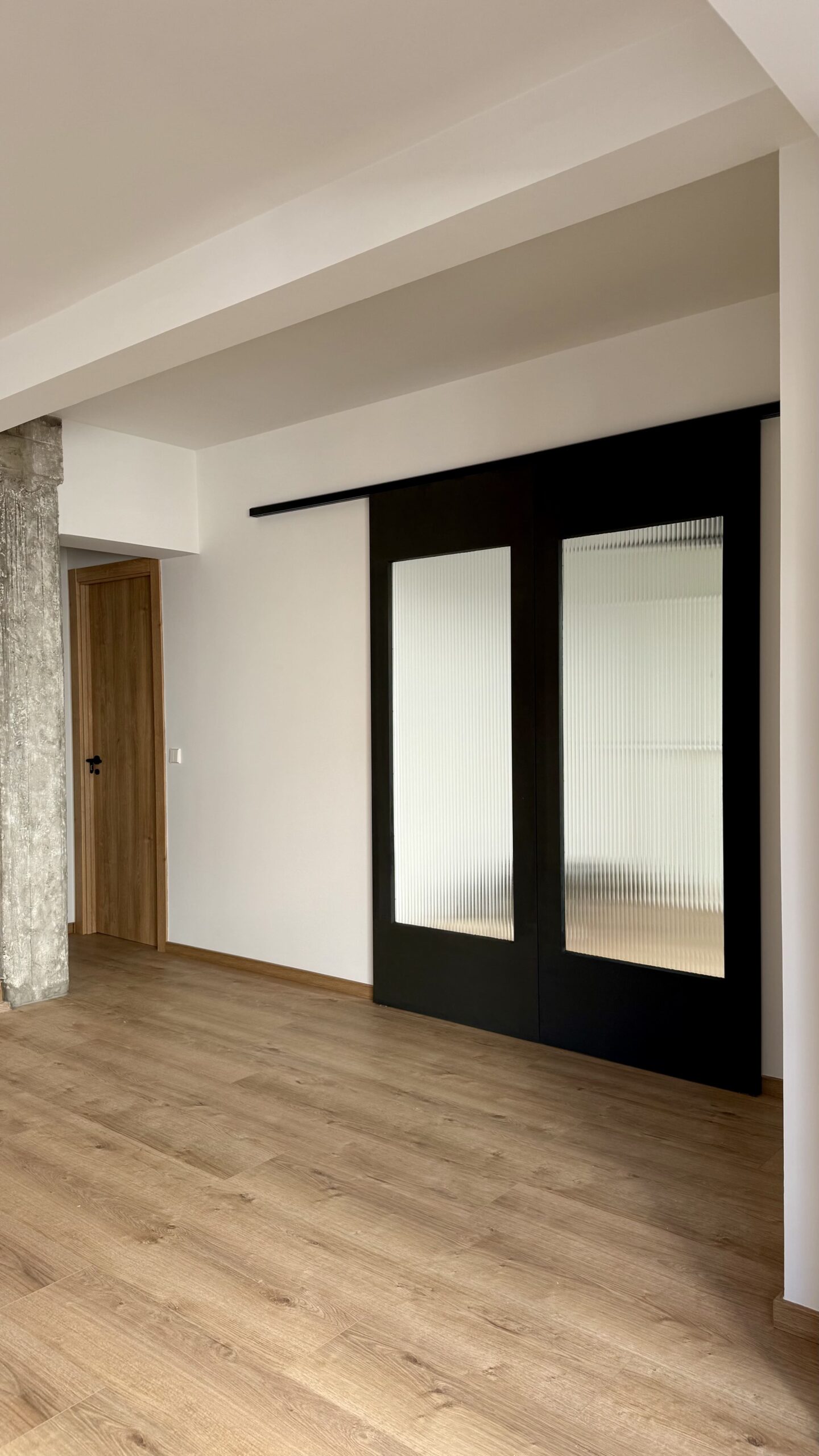 Estancia con puertas correderas de cristal y suelo de madera