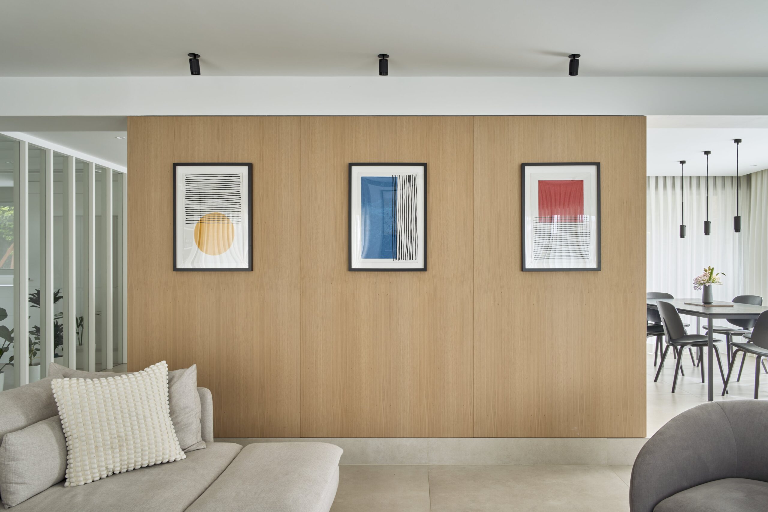 Panel de madera con cuadros entre el salón y el comedor