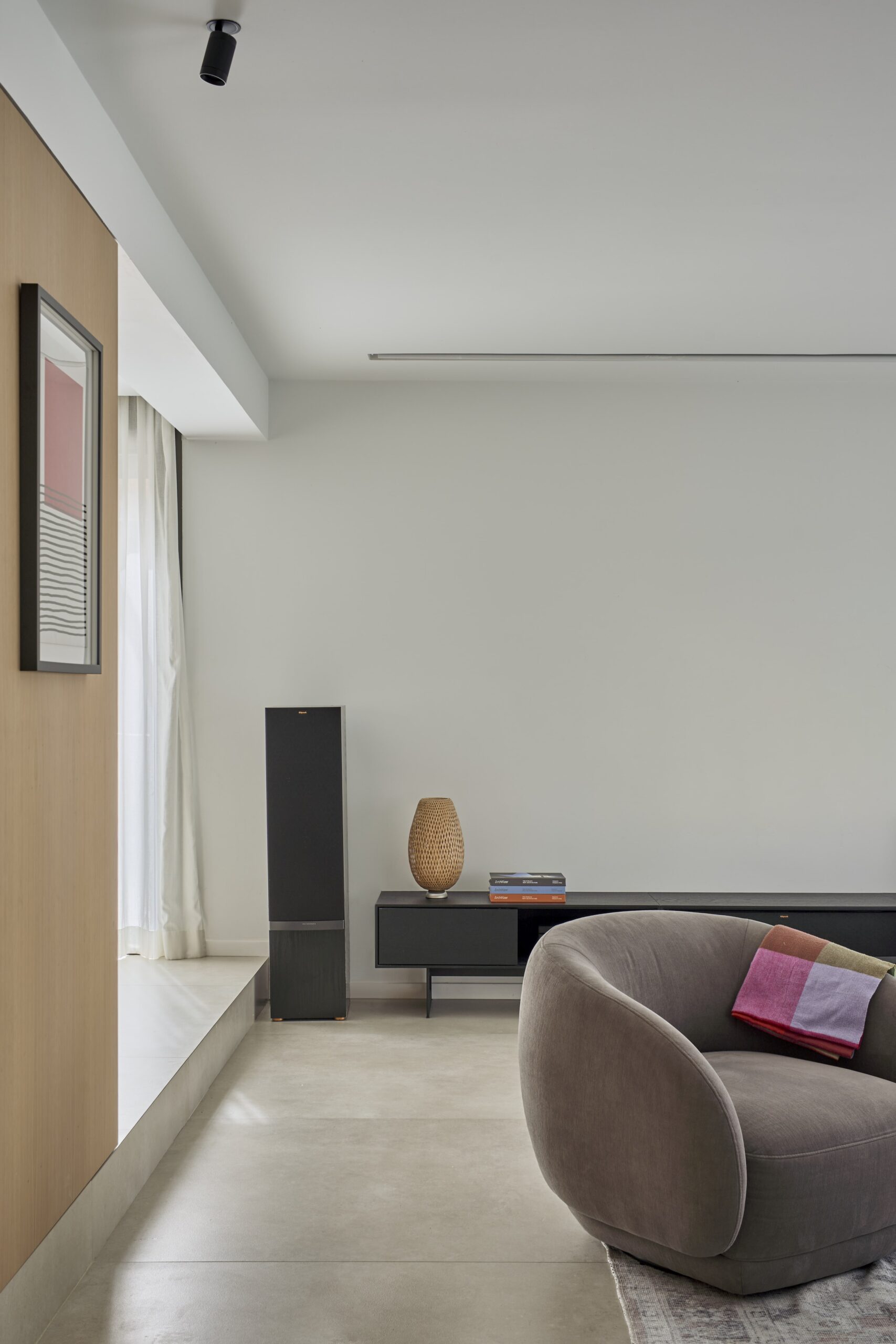 Salón con butaca gris y mueble bajo de televisión
