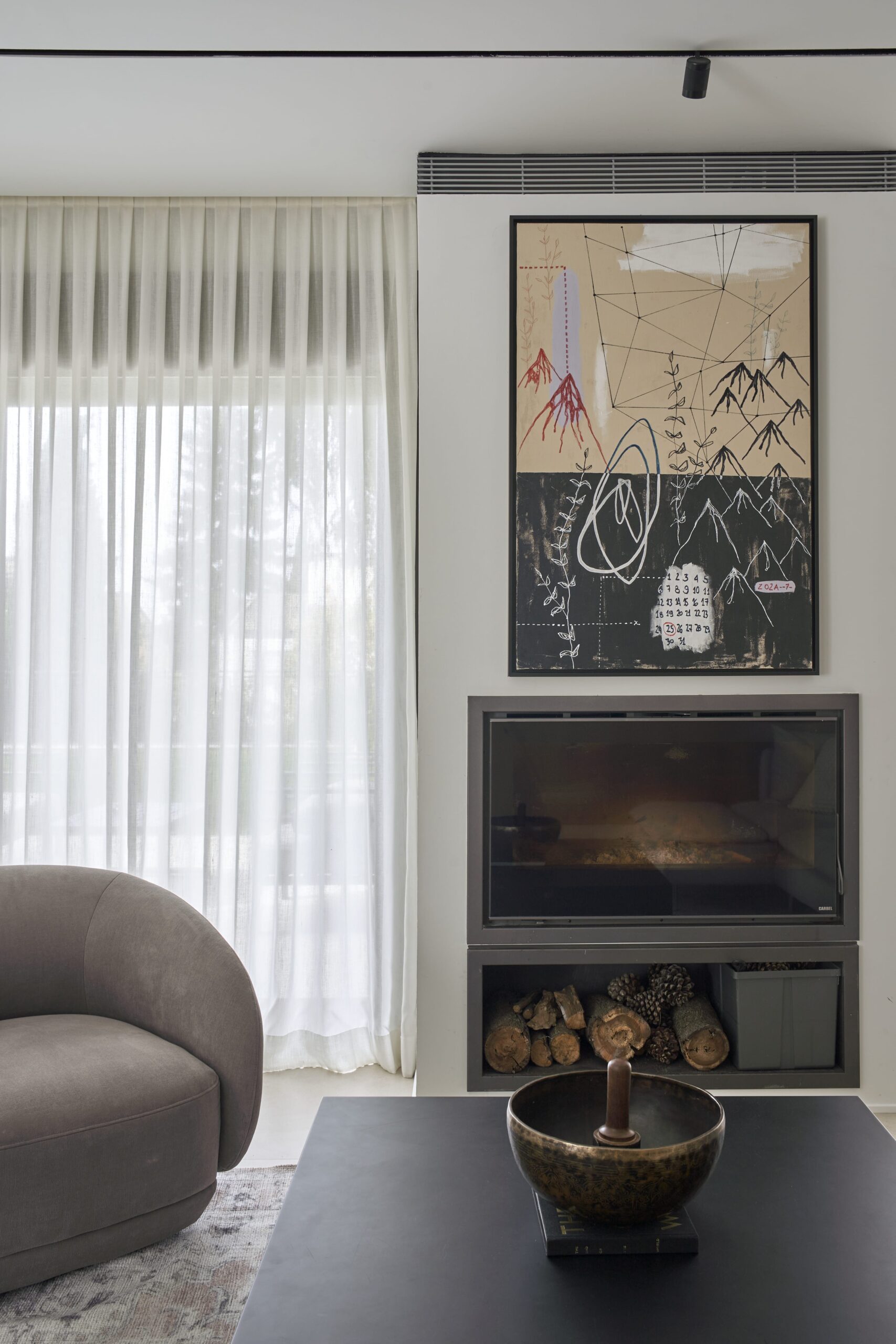 Salón con chimenea empotrada y cuadro sobre ella en una casa reformada