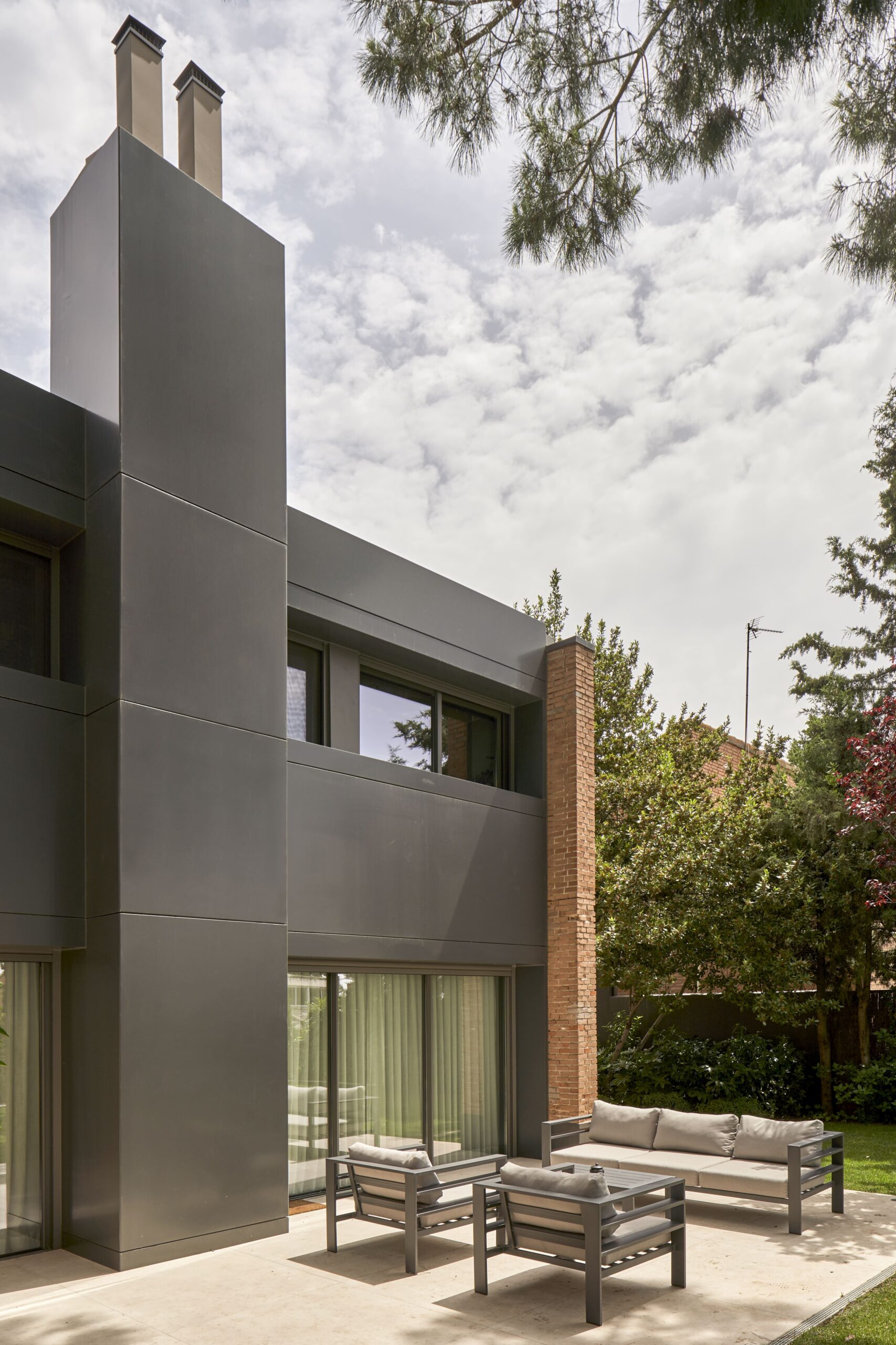 Fachada con volumen de chimenea en gris oscuro