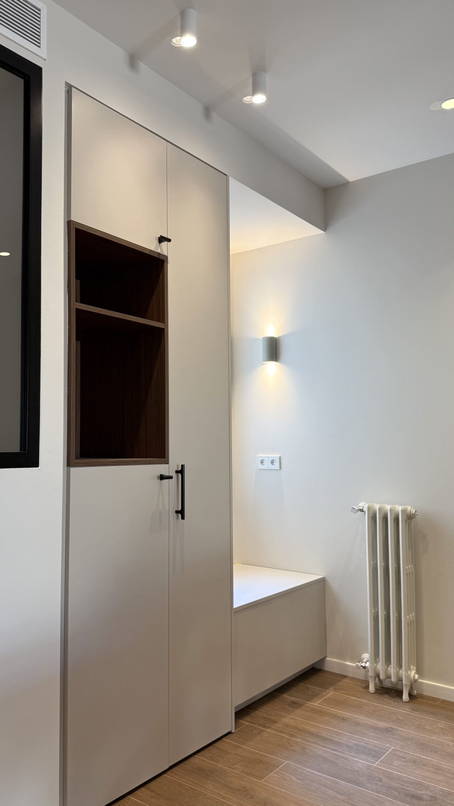 Habitación con banco bajo la ventana y armario a medida