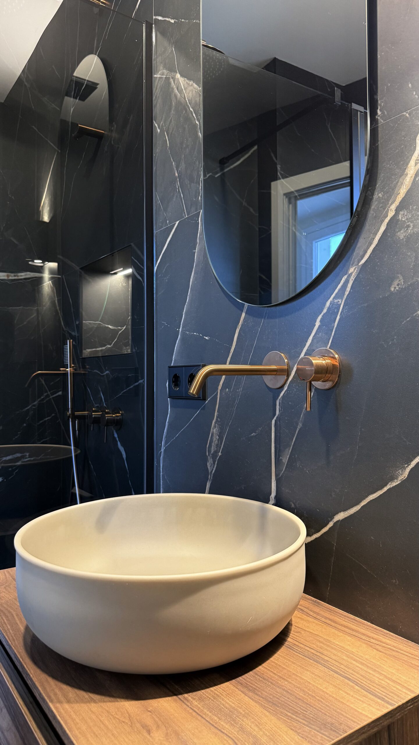 Lavabo sobre encimera y grifo de pared en bronce