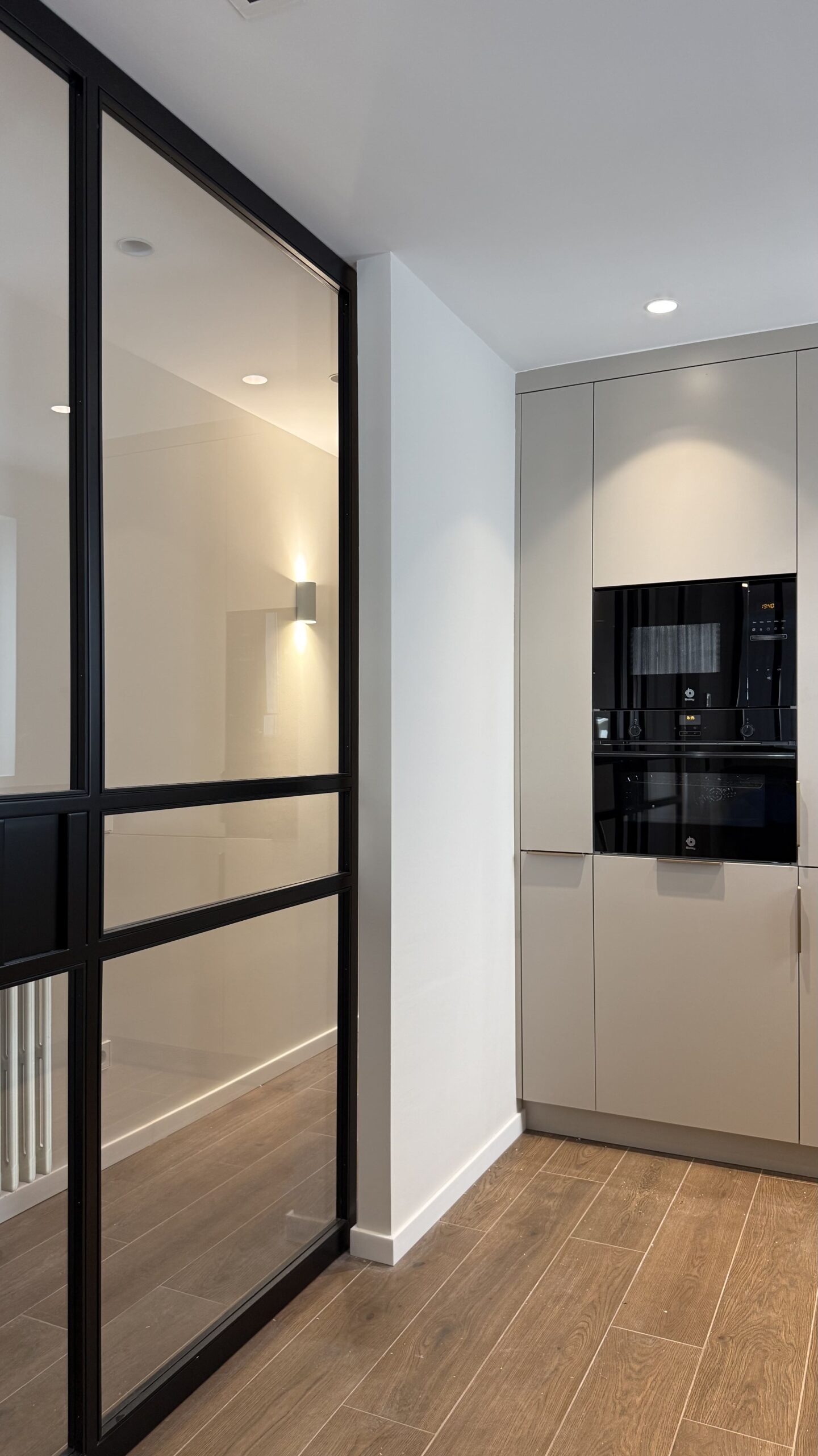 Puerta de vidrio con perfilería negra hacia la cocina