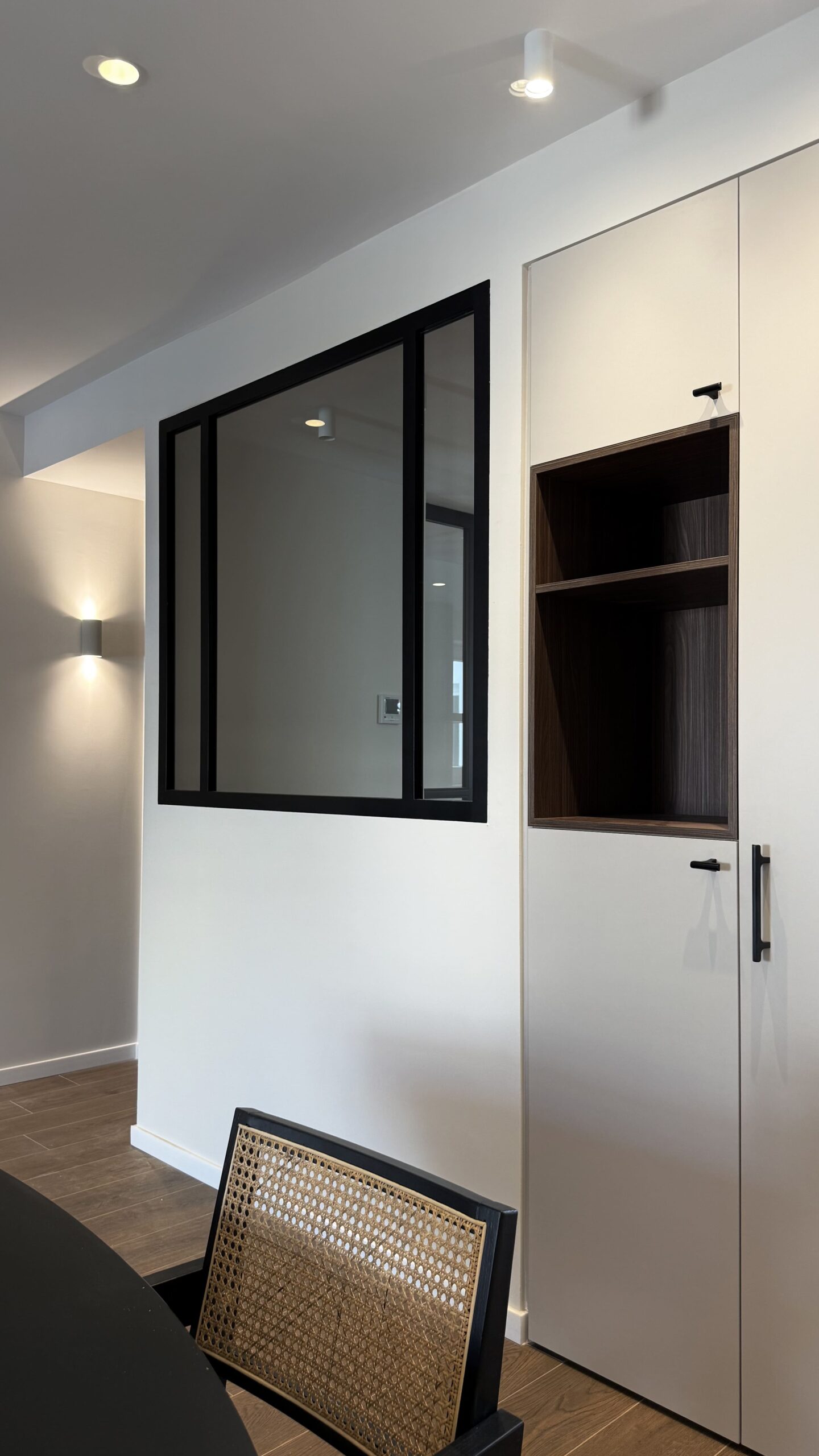 Ventana interior con perfilería negra y armario a medida