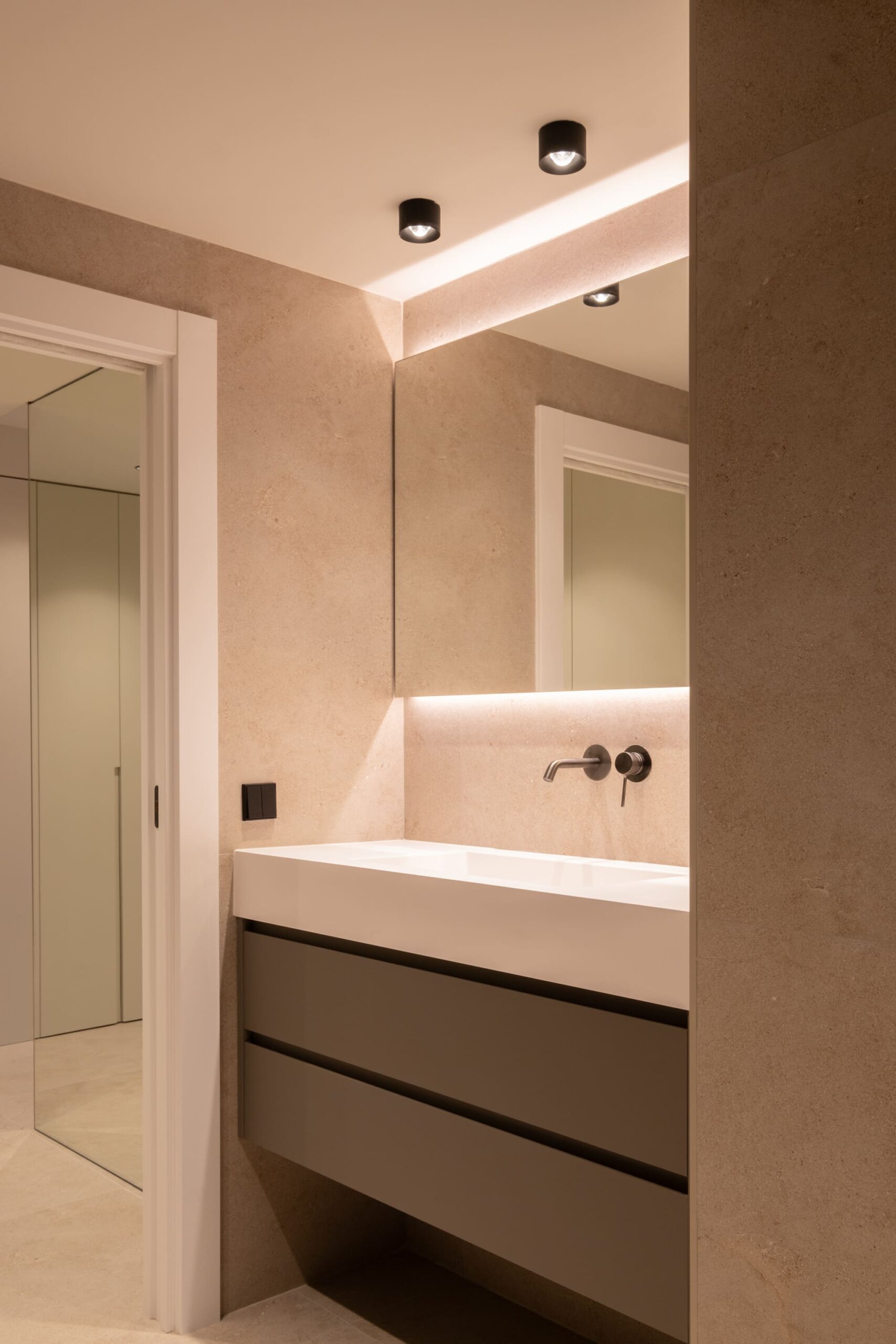 Baño en tonos arena con espejo iluminado