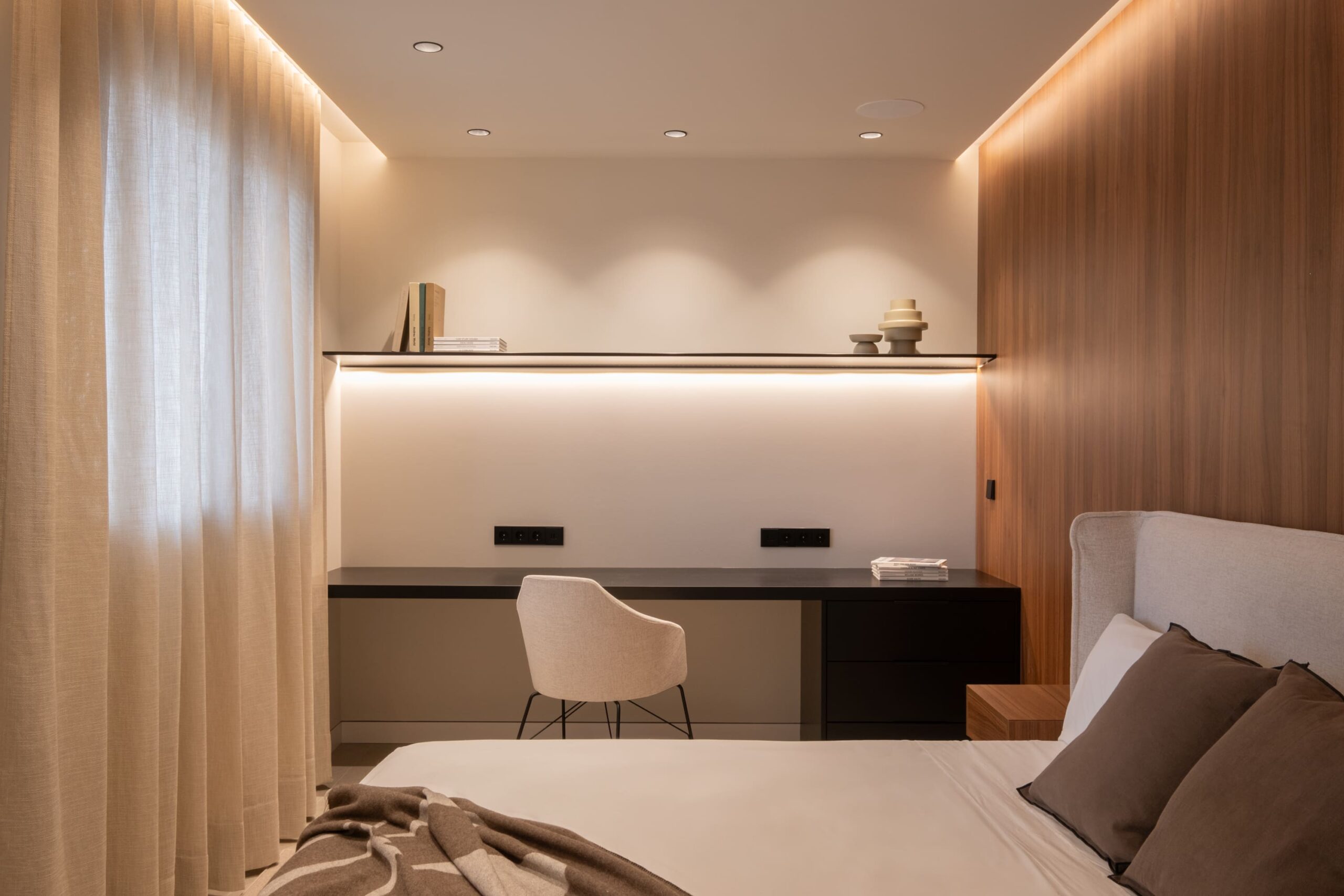 Dormitorio con escritorio y estante iluminado