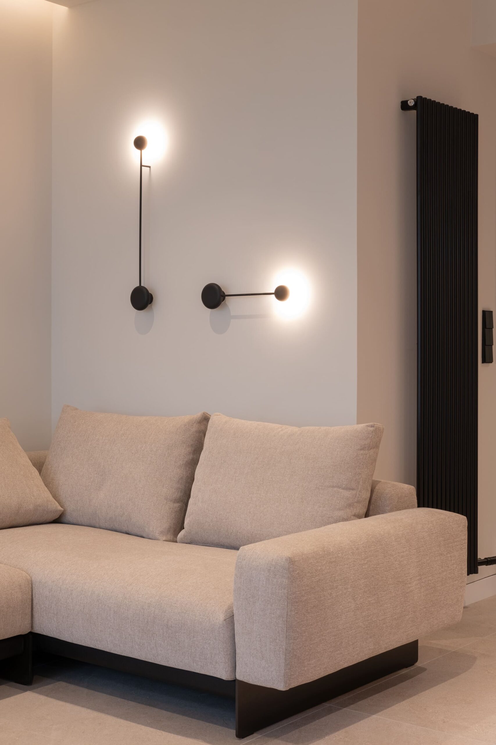 Sofá beige y apliques de pared negros