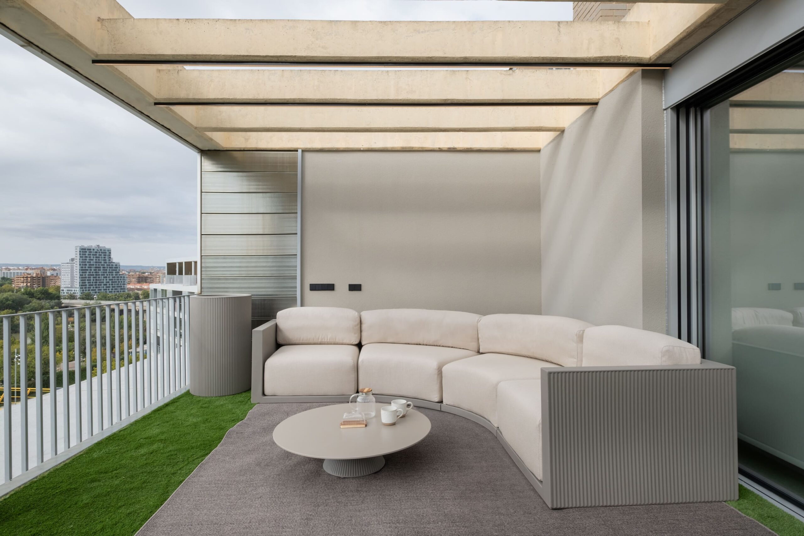 Terraza cubierta con sofá curvo en el proyecto JA19