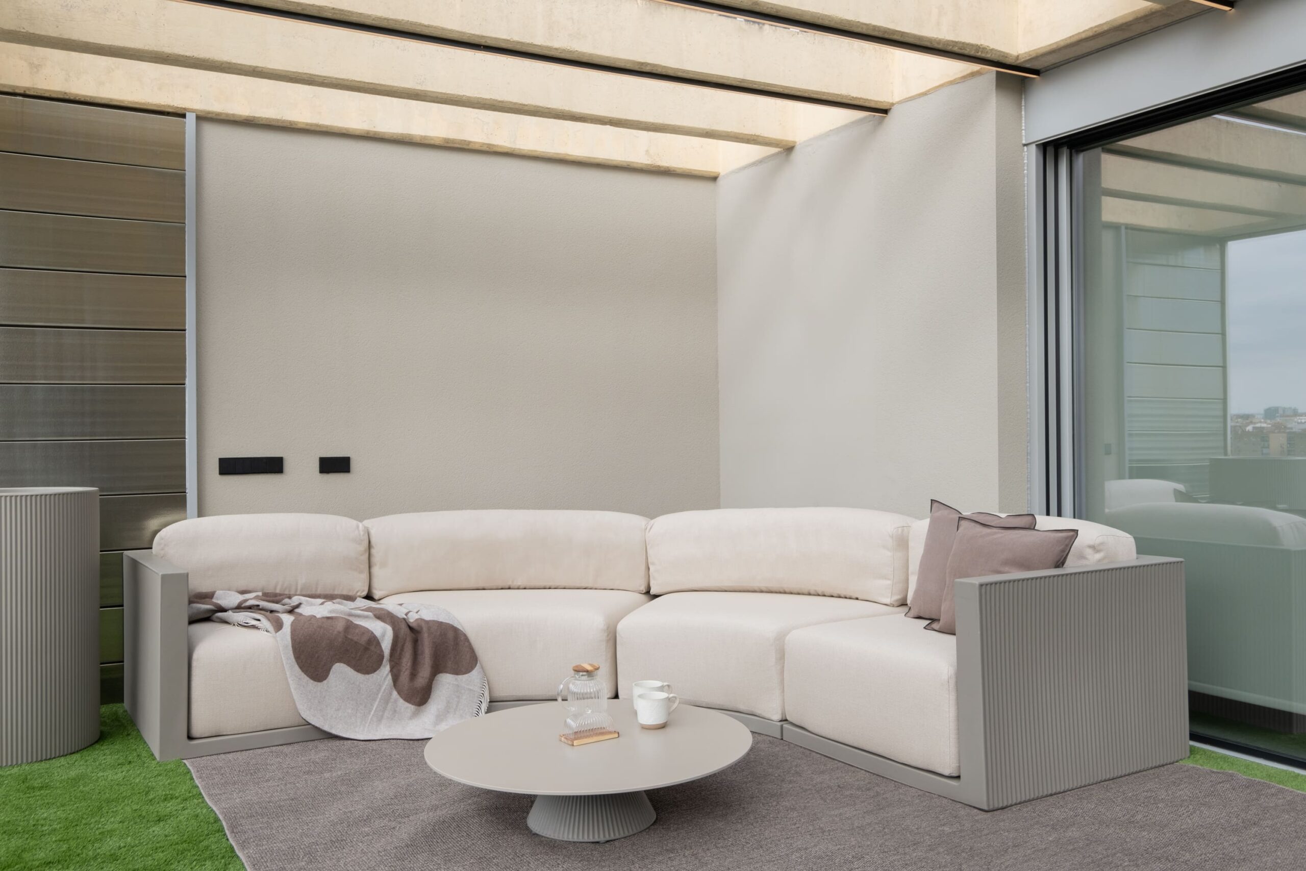 Terraza cubierta con sofá exterior y mesa de centro