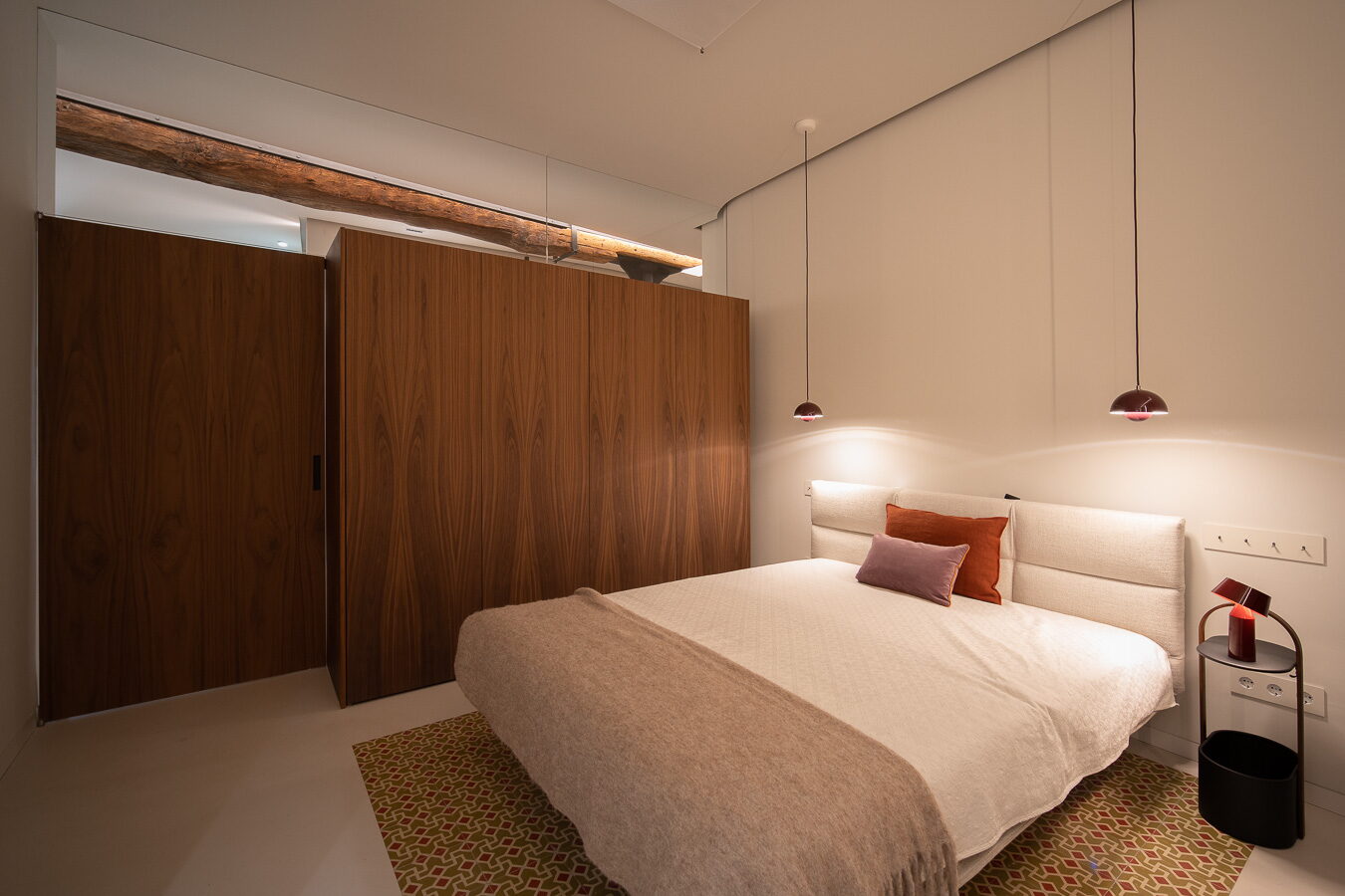 Dormitorio con viga de madera y revestimiento de nogal
