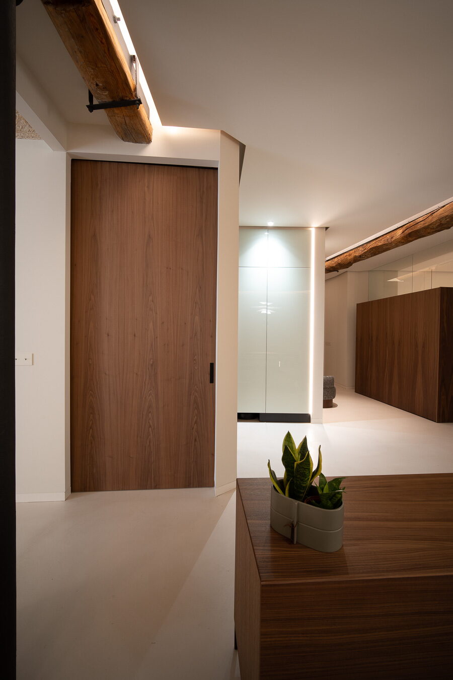 Puerta de nogal a techo bajo una viga de madera vista