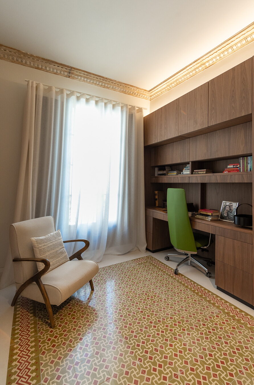 Zona de estudio con butaca y librería de nogal en el proyecto A40