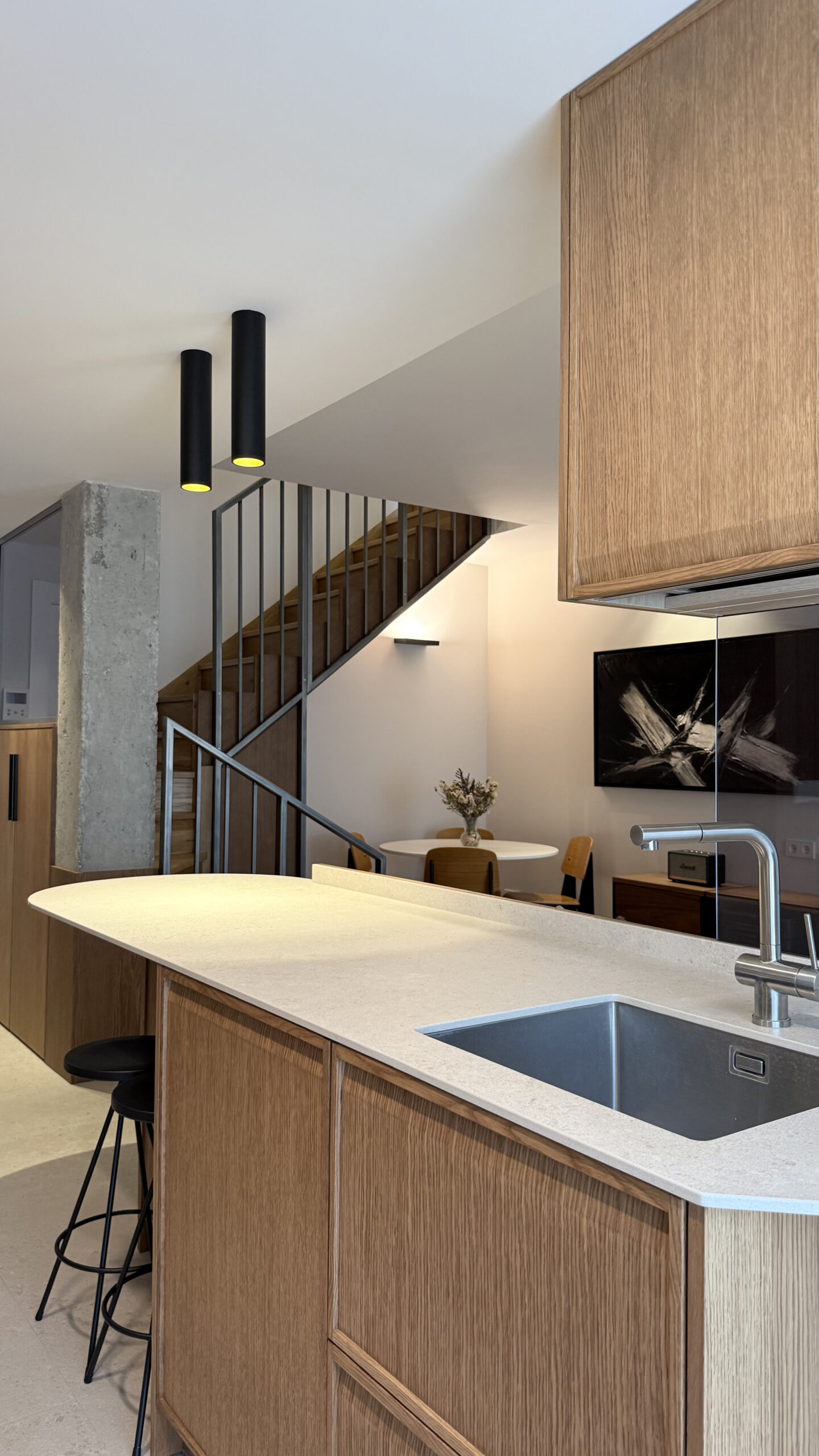 Cocina abierta con isla de madera en la reforma de una vivienda de 80 m²