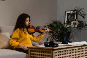 nina tocando el violin en sofa